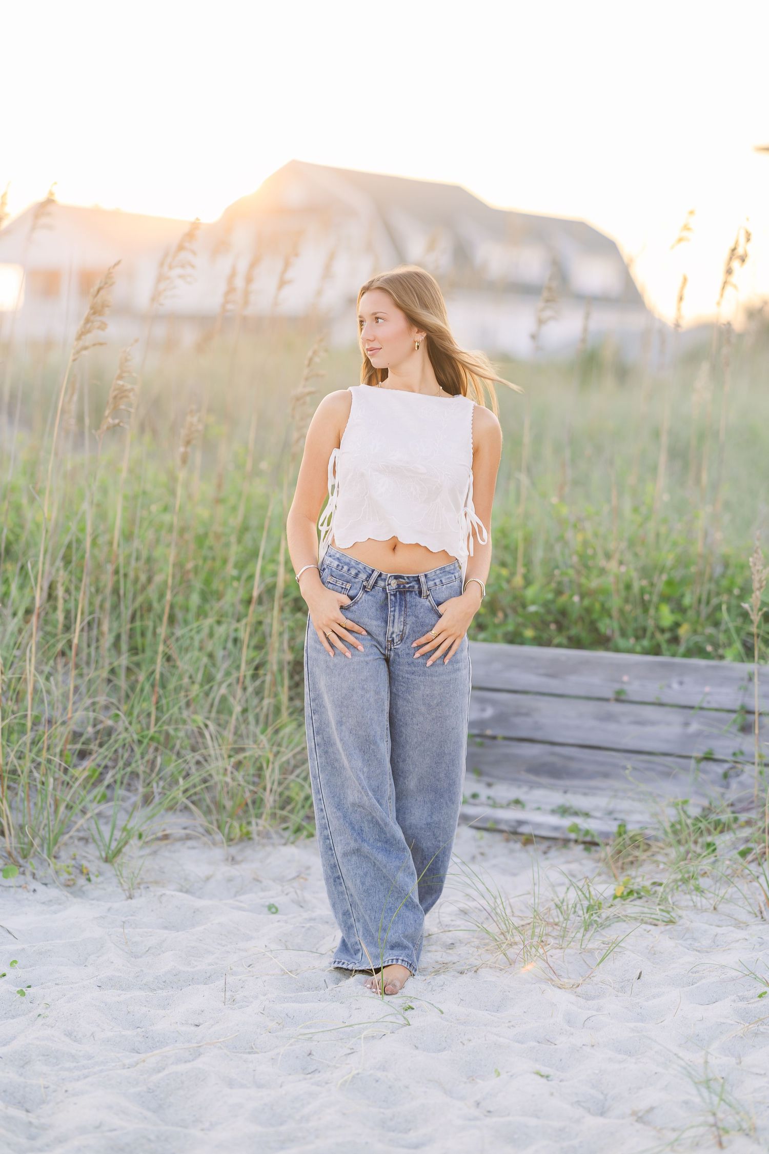 Candid beach portraits with vintage-style jeans and crop top at sunset.