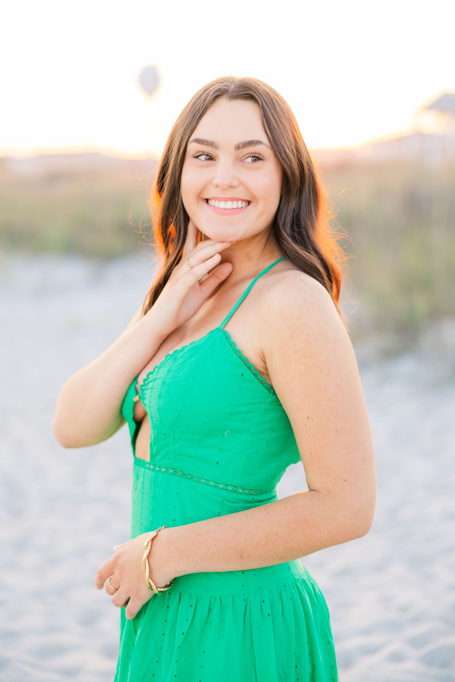 Joyful summer portraits featuring a green sundress on a sandy beach setting.