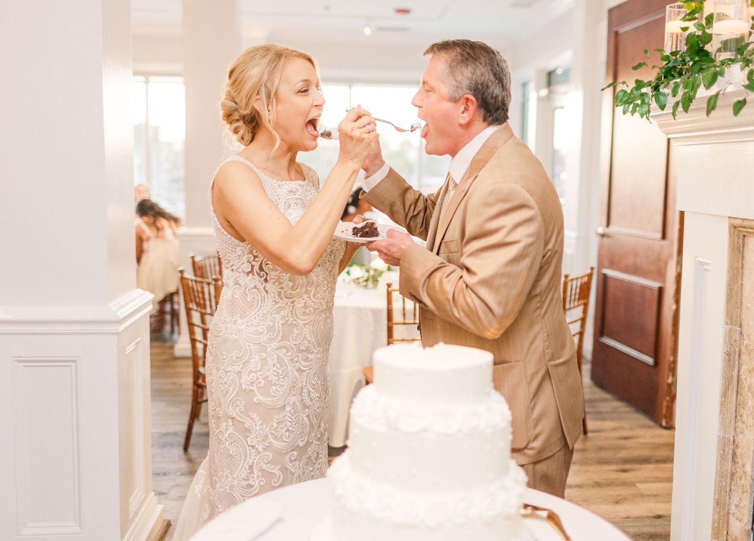Elegant indoor wedding reception venue with white decor and romantic lighting.