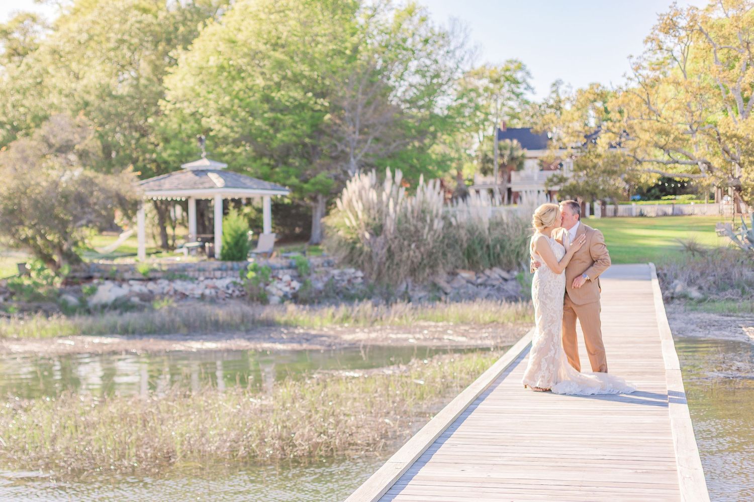 Wooden boardwalk stretches across natural landscape with water views.