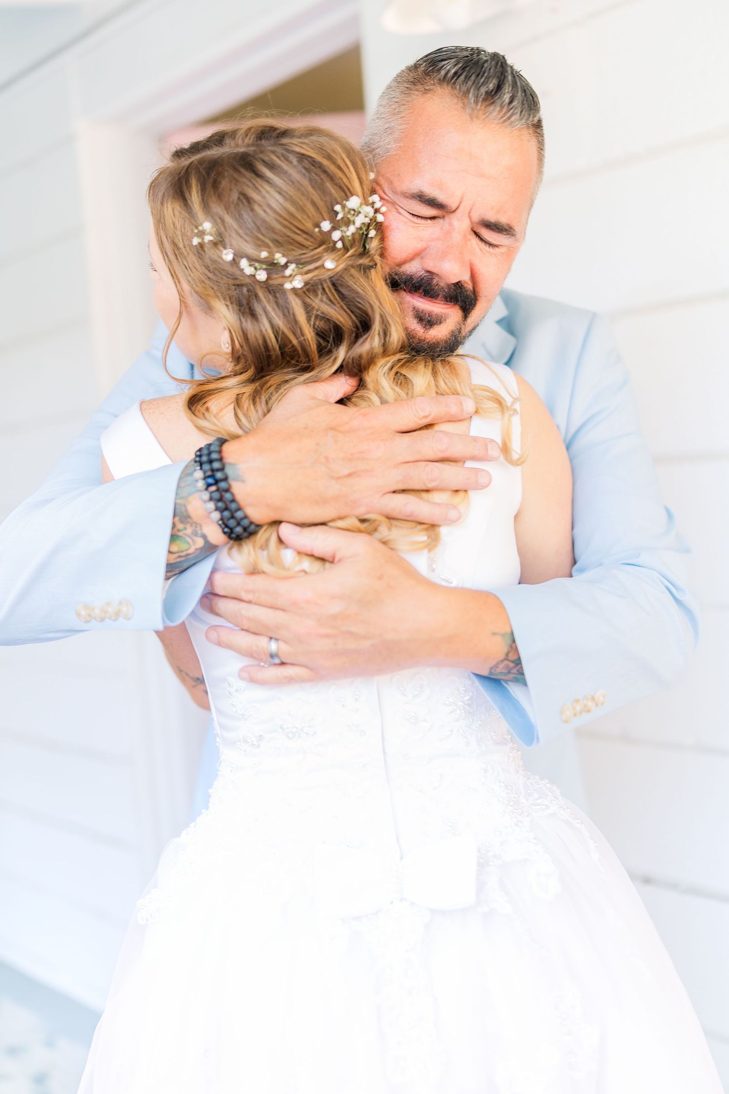 Emotional wedding moment captured in soft light with bride in white dress southport elopement wedding bride groom light and airy classic