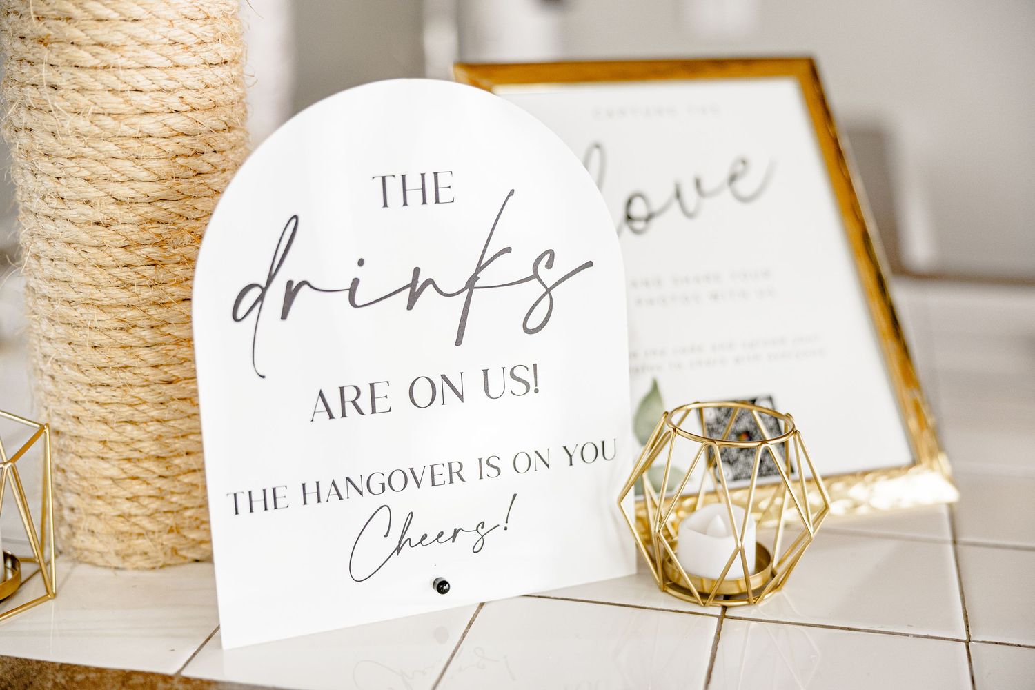 Gold-framed wedding signage and decorative elements on a white tablecloth wedding groom bride lake Gaston photographer light airy