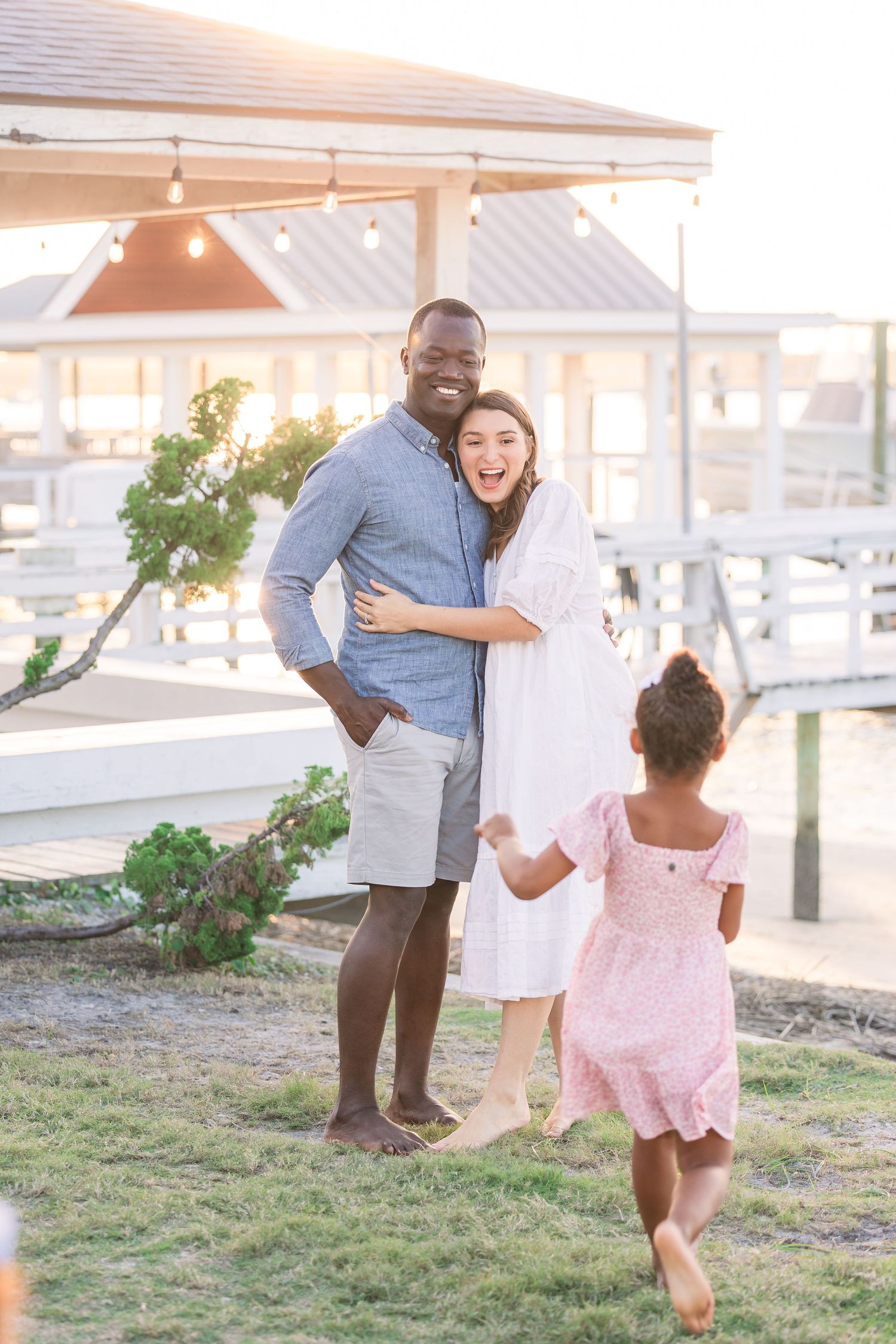 Family playing and laughing together during sunset beach photoshoot.
