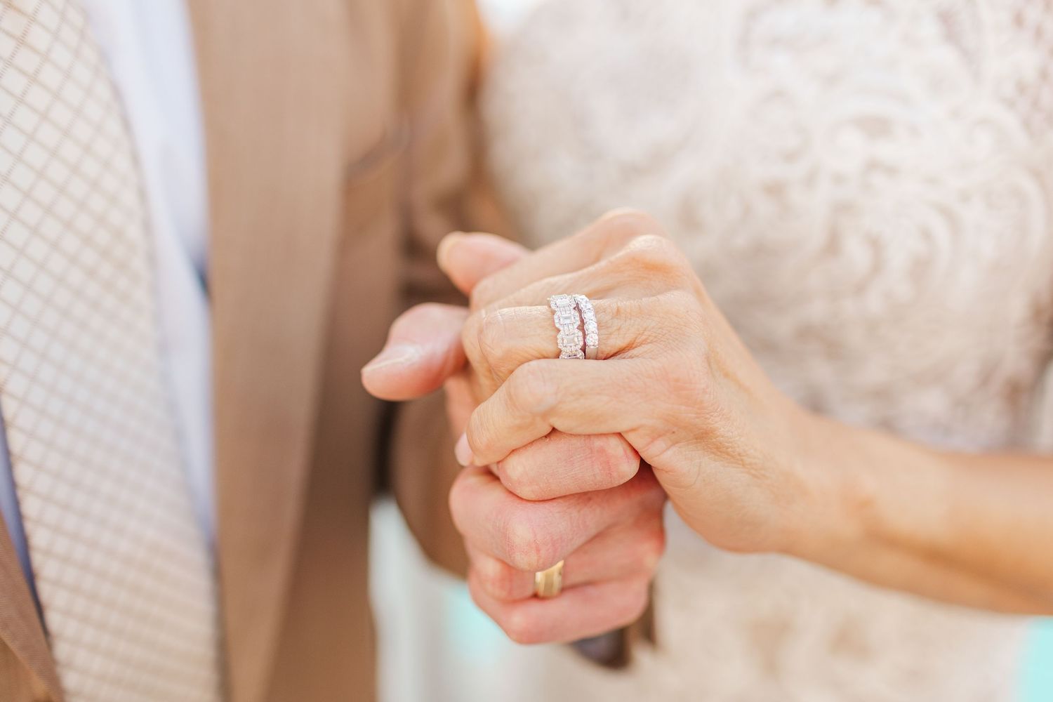 Close-up of hands showing elegant wedding rings and jewelry.