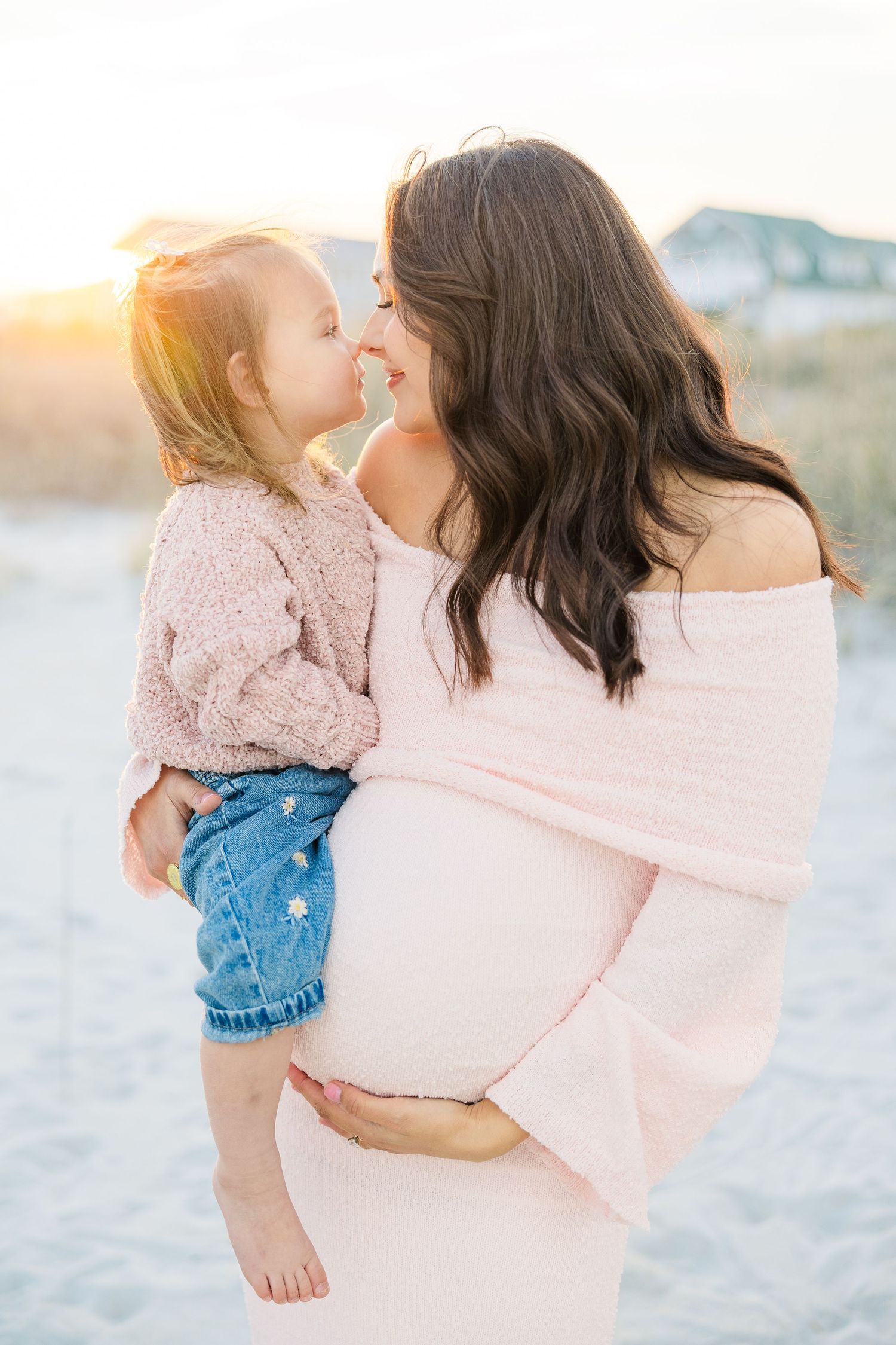 Sweet candid moment captured on a beach with matching pink and blue outfits.