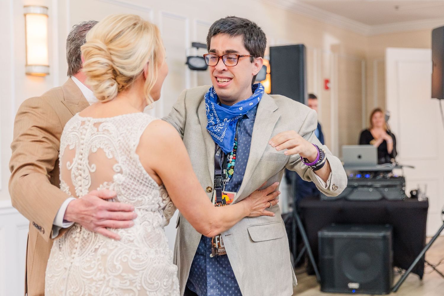 Wedding celebration showing multiple emotional interactions between guests in a bright indoor space.