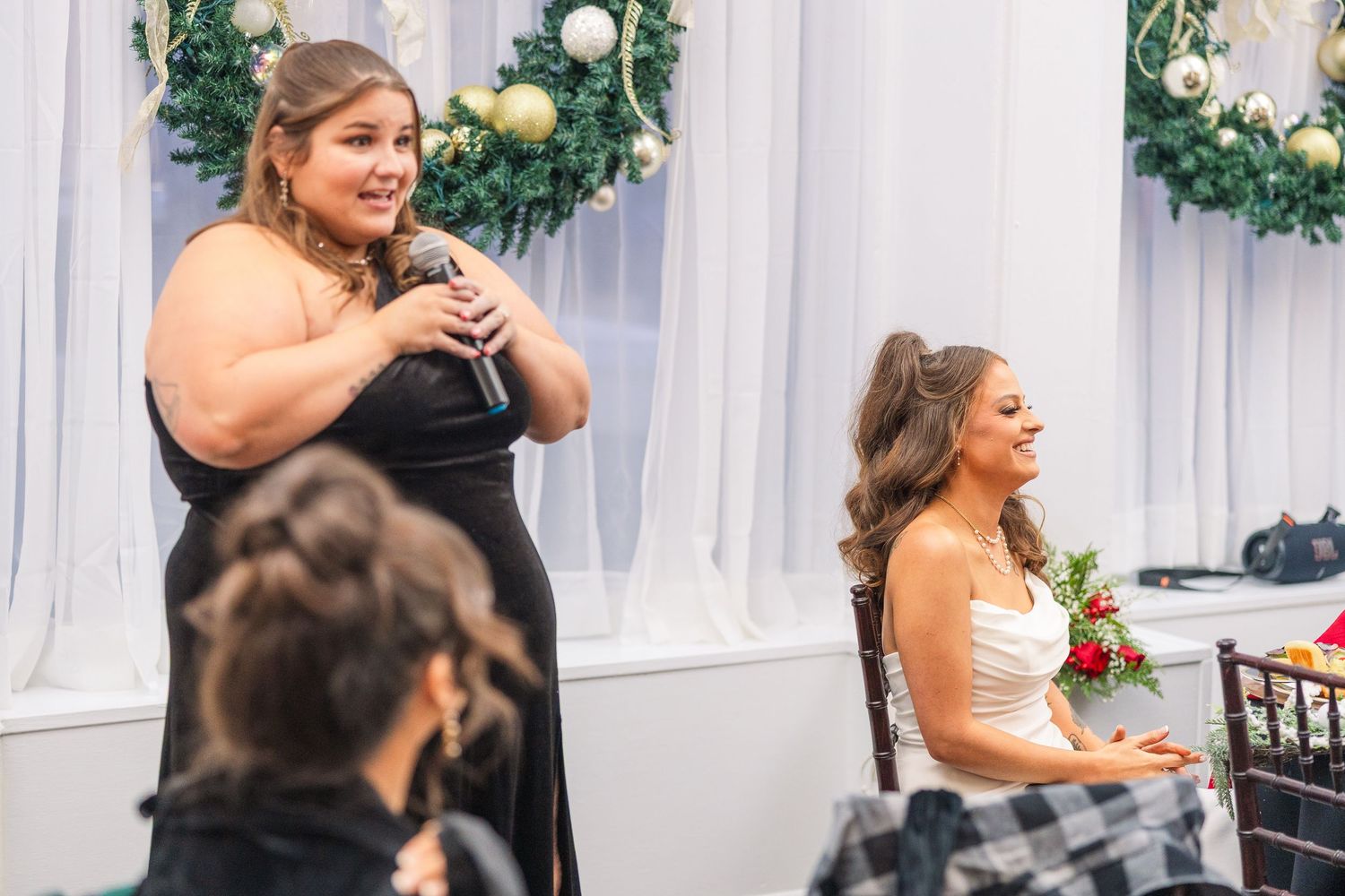 Two attendees at a wedding reception share a moment during dinner celebrations.