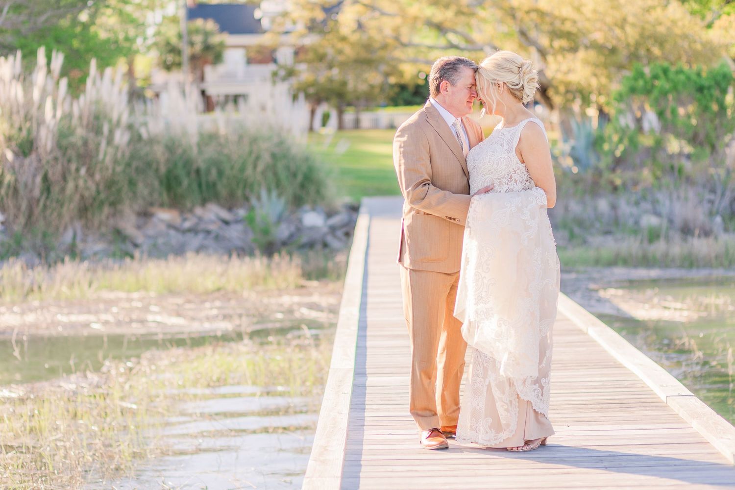 Romantic couple strolls on waterfront boardwalk during golden hour.