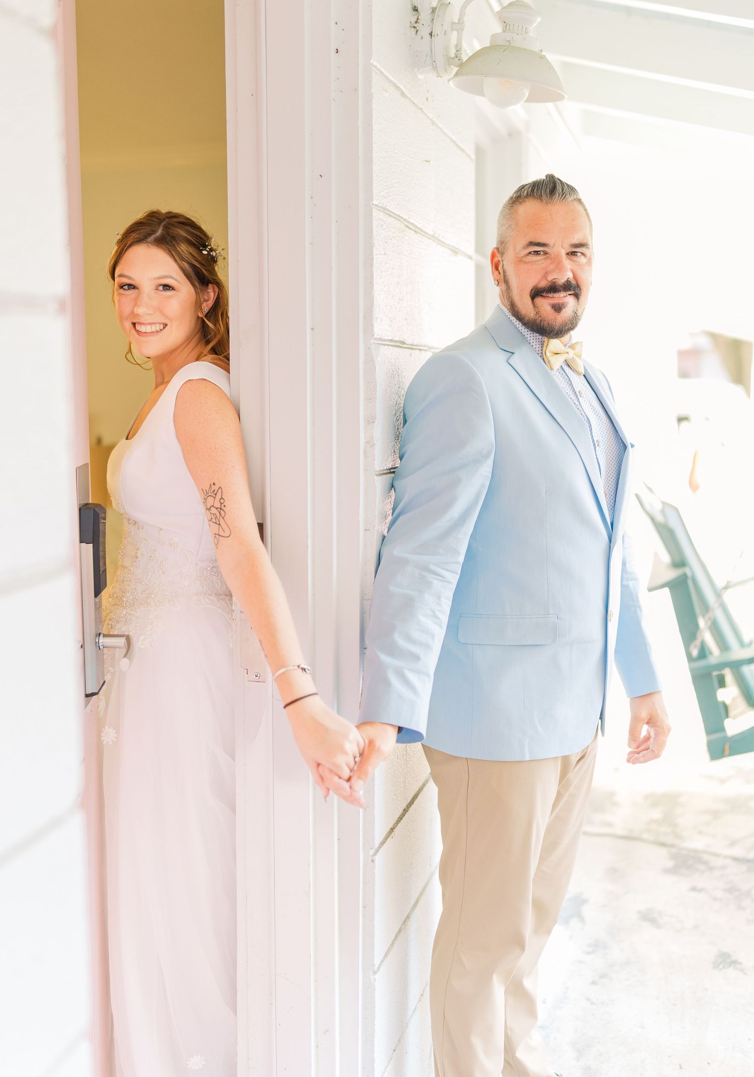 Wedding first look moment captured in bright hallway with light blue and white decor southport elopement wedding bride groom light and airy
