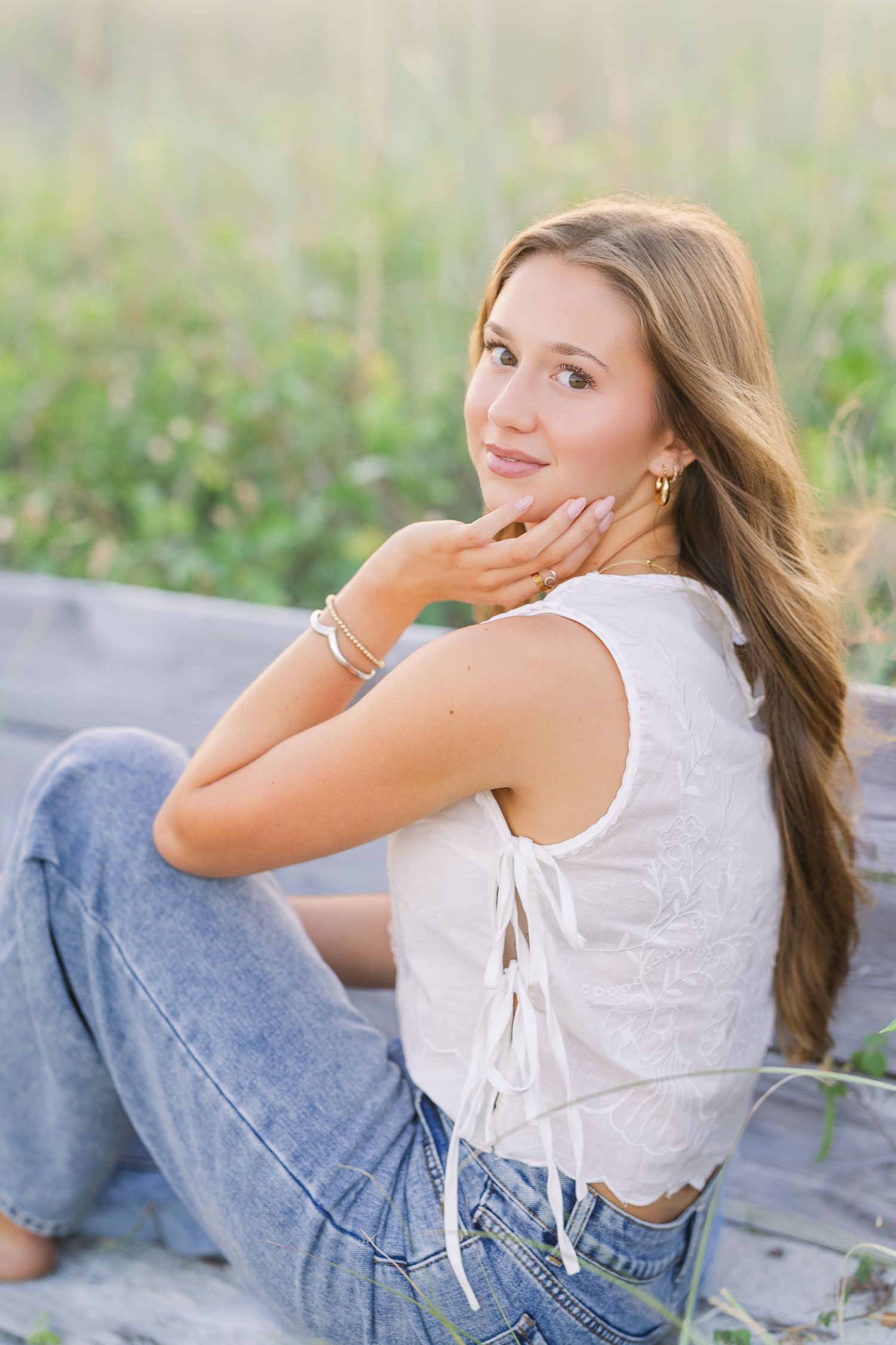 Relaxed portrait session on a beach blanket with casual denim and white top.