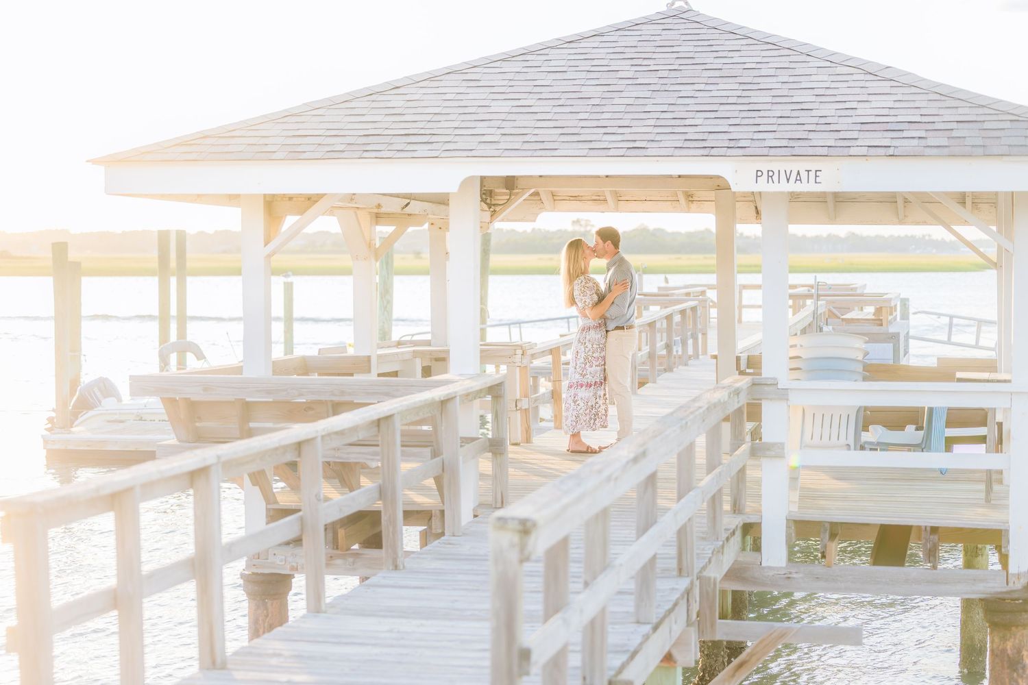 A dreamy sunlit moment captured on a white wooden pier overlooking the water.