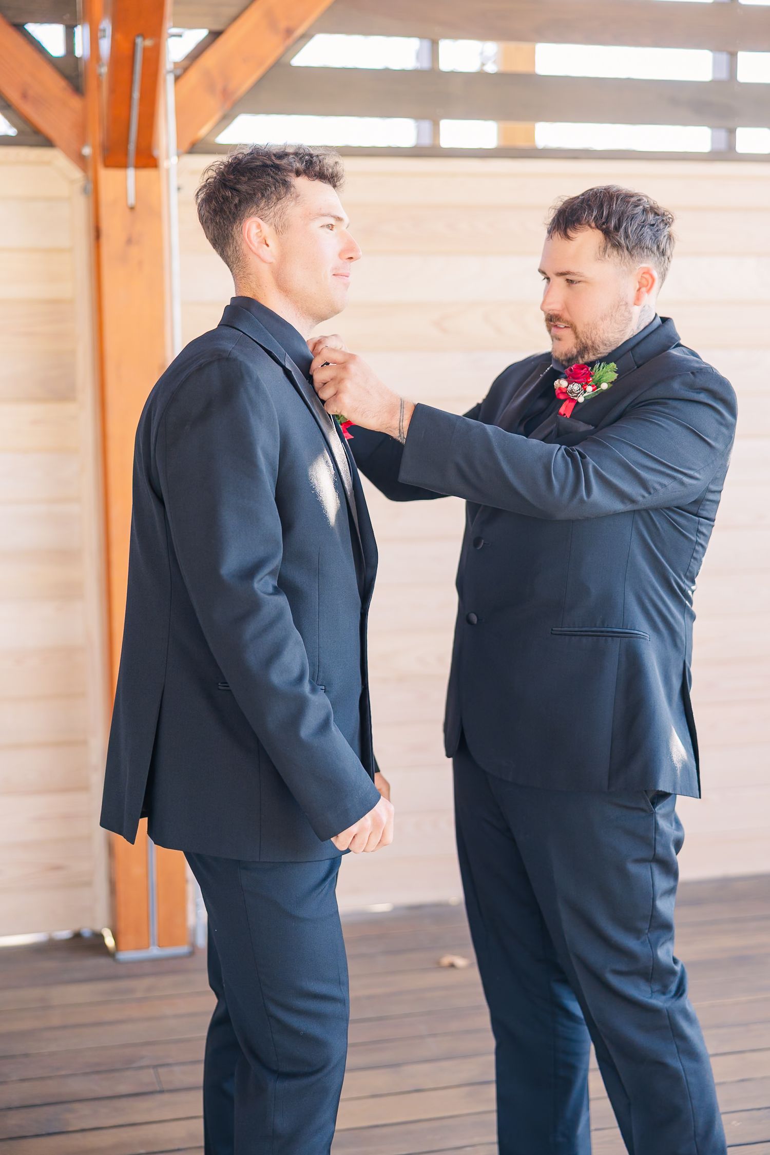Two people in dark suits share emotional moment during wedding celebration wedding groom bride wilmington North Carolina photographer light