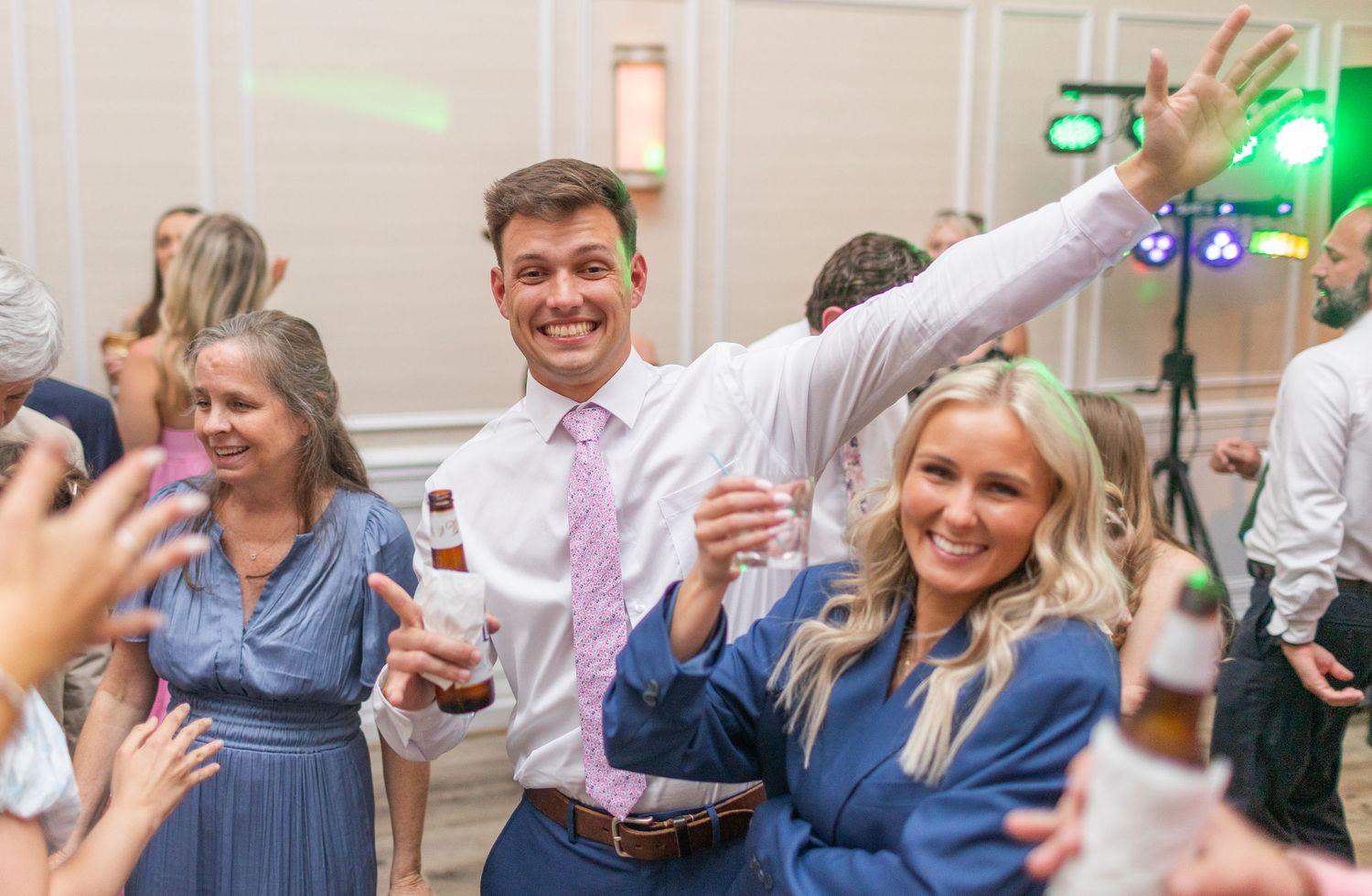 Wedding party guests dancing and celebrating  landfall wedding bride groom light and airy classic wilmington Wrightsville Beach
