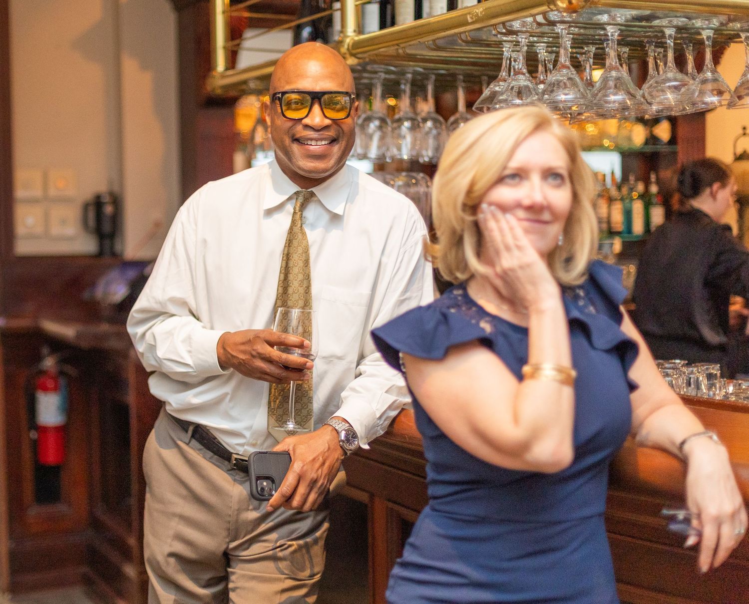 Party guests share a lighthearted moment at a bar during a celebration.