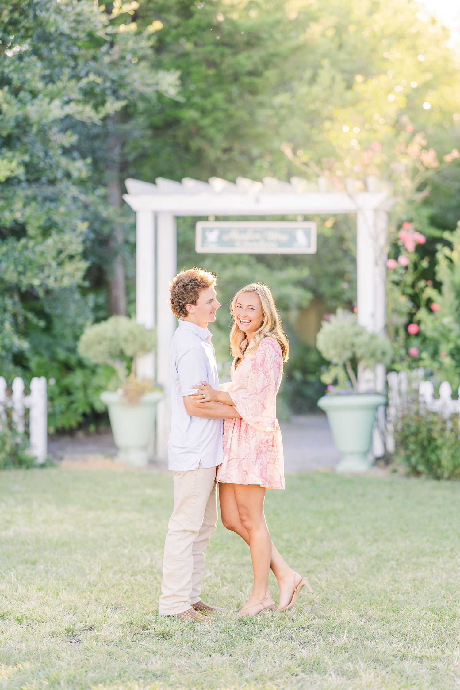 A romantic outdoor photoshoot in a garden setting with white pergola and soft lighting.