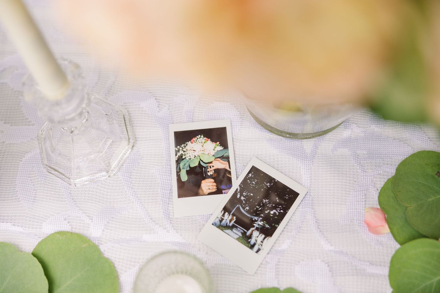 Polaroid photographs arranged with greenery on a light colored table wedding groom bride wilmington North Carolina photographer light and ai