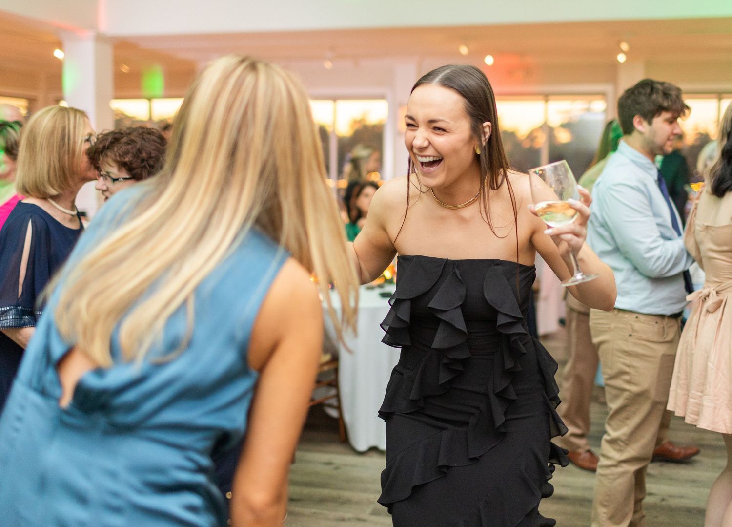 Guests enjoying a lively moment of laughter and dancing at an indoor celebration.
