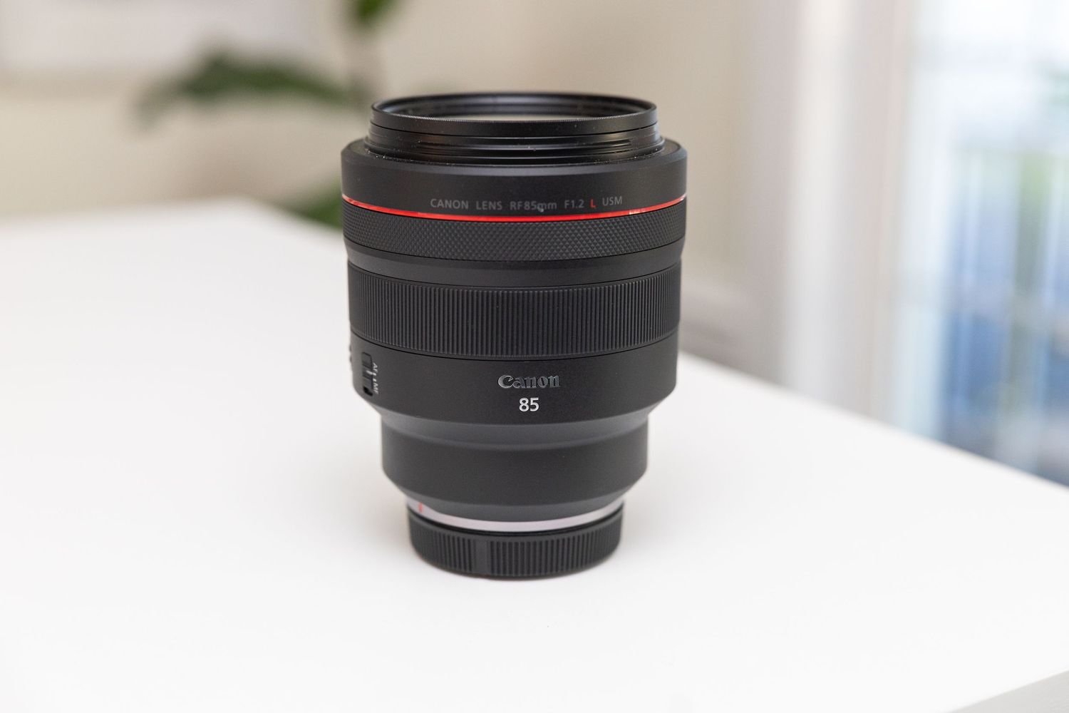 Multiple camera lenses arranged in a row on a white surface showing different focal lengths and brands.
