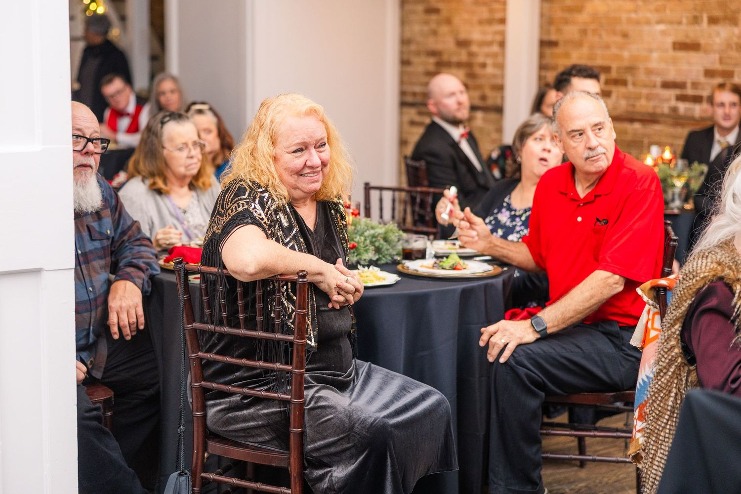 Wedding guests enjoying dinner at tables decorated with holiday greenery and red accents wedding groom bride wilmington North Carolina photo