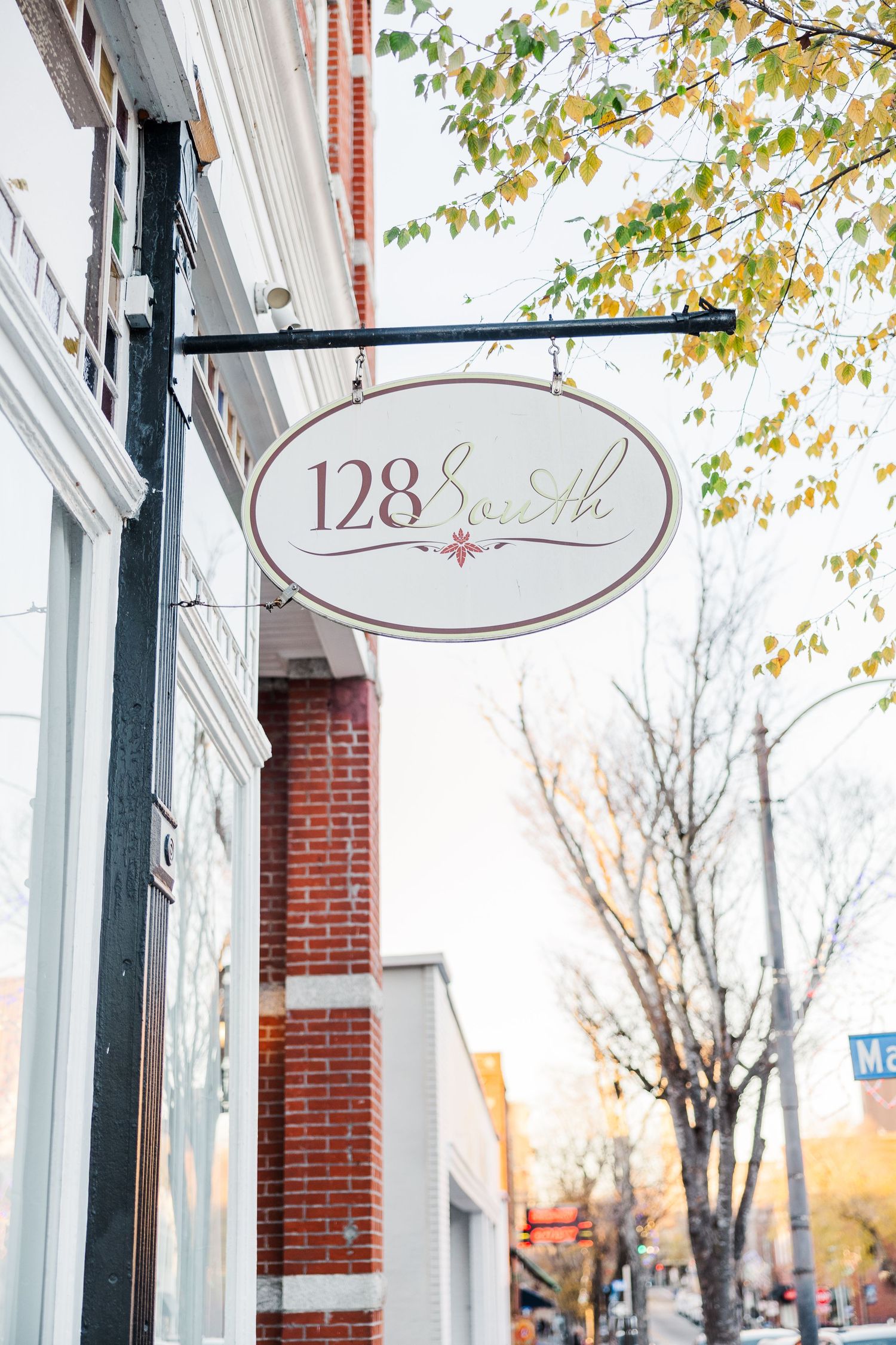 Elegant storefront sign reading '128' with brick and white architectural details.