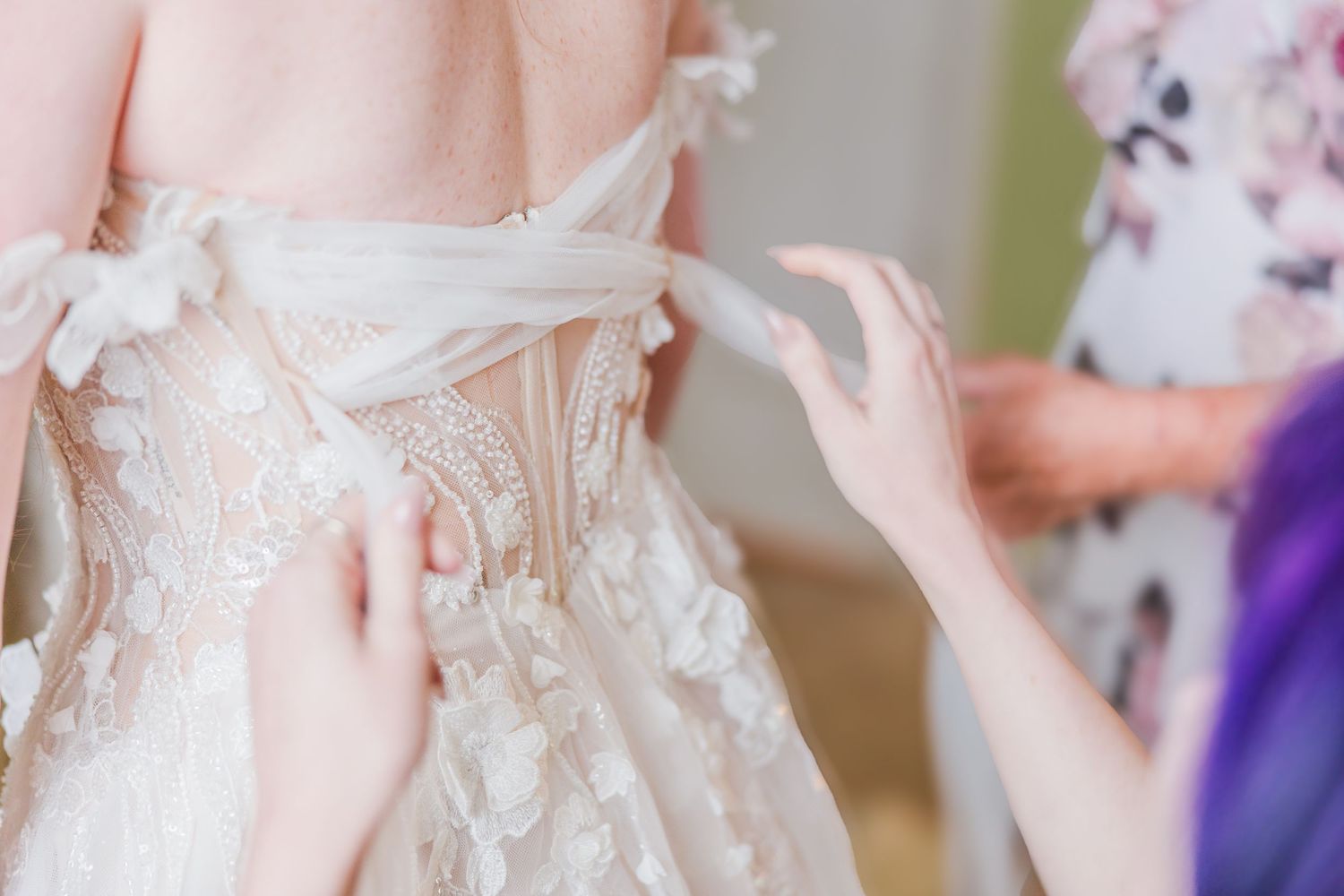 Close-up detail of intricate lace and buttons on the back of a wedding dress in a backyard wedding in wilmington, nc