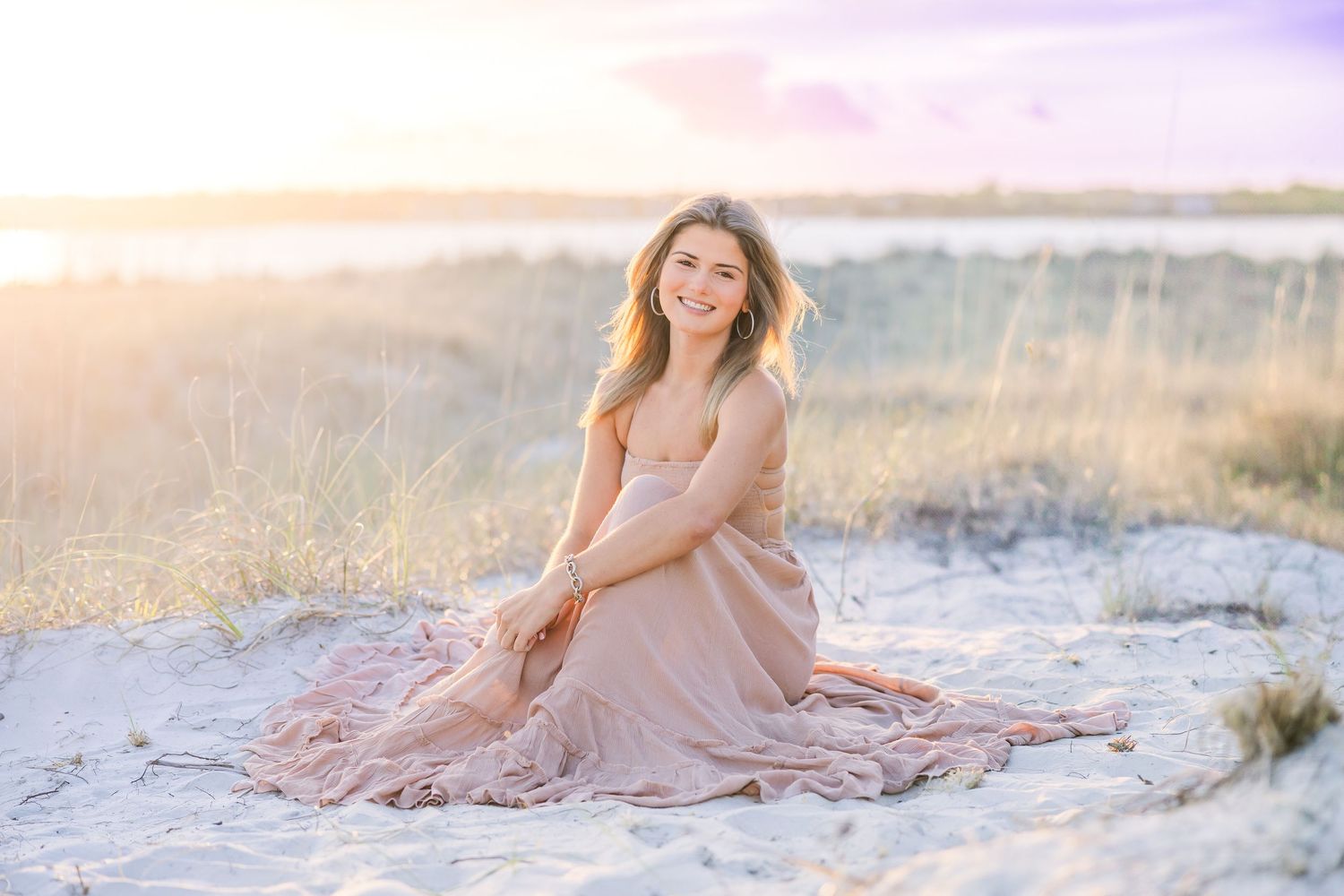 Sunset beach portrait session with soft pink sky and coastal dunes.
