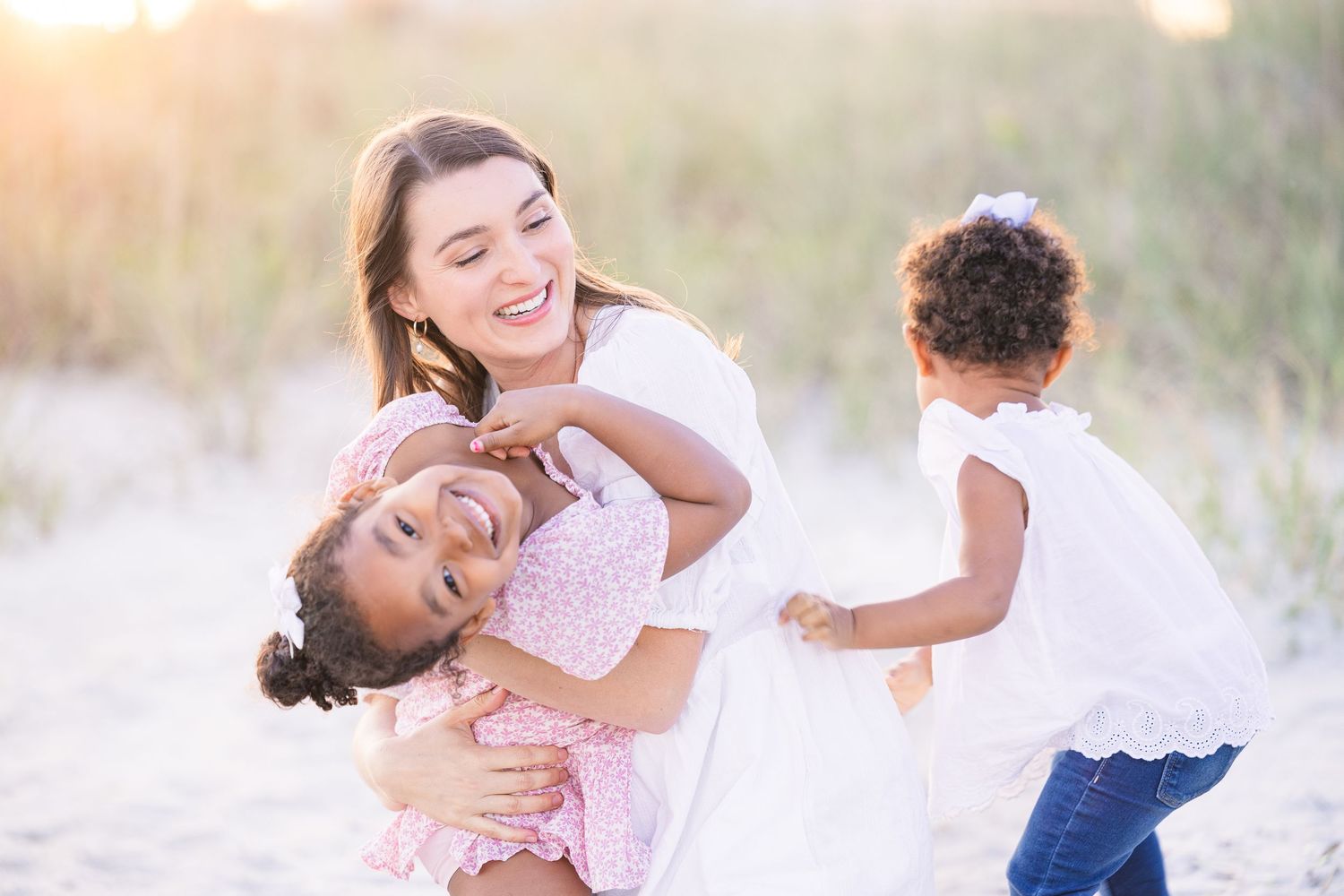 Candid moments of family affection captured during a beach photoshoot.
