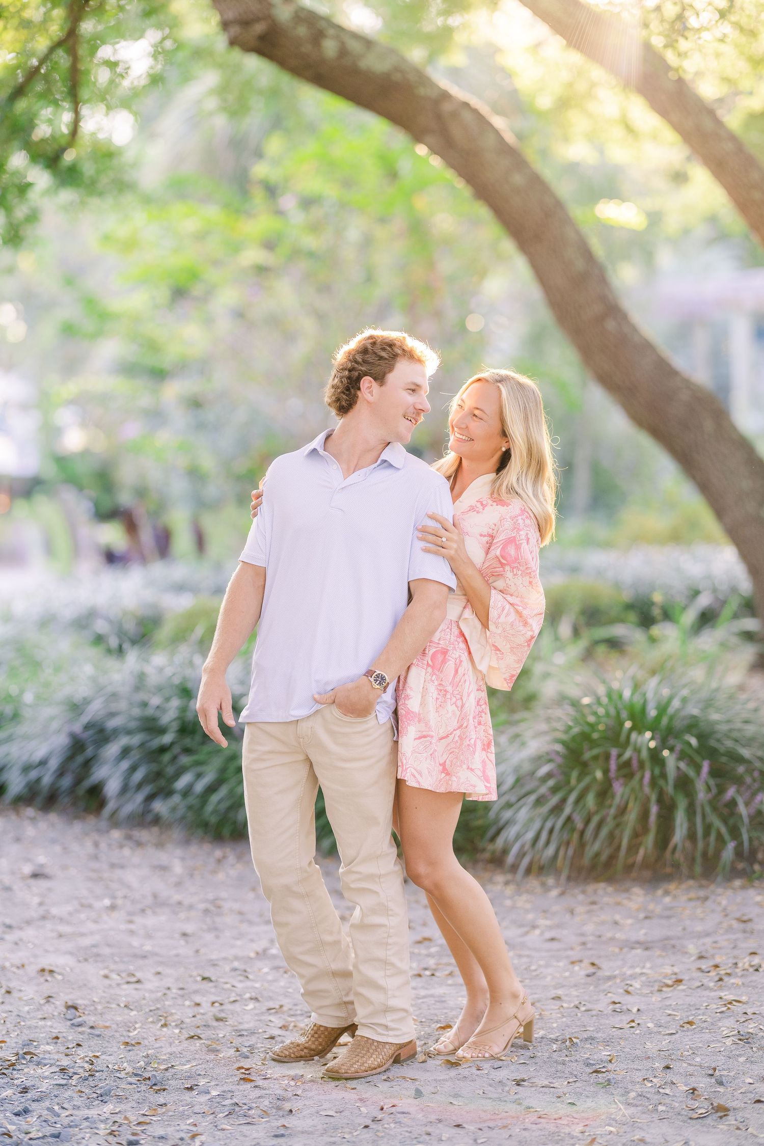 Playful outdoor portraits on a dirt path with trees and foliage.