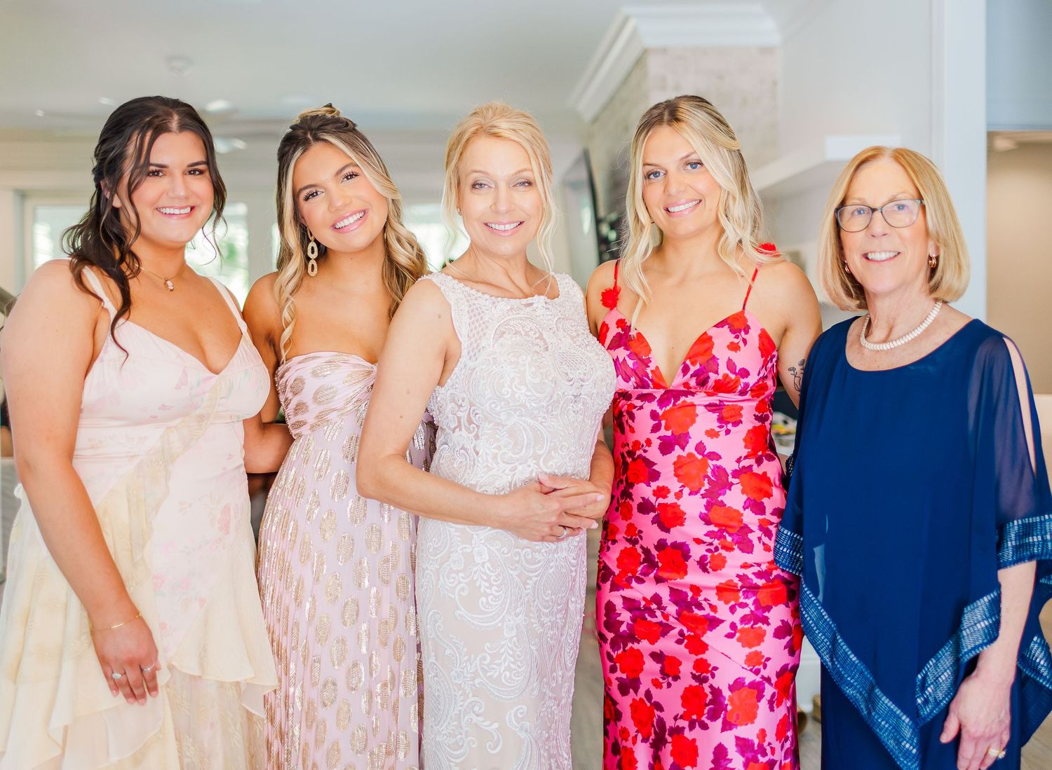 Wedding party group photo with bridesmaids in pink and navy dresses.