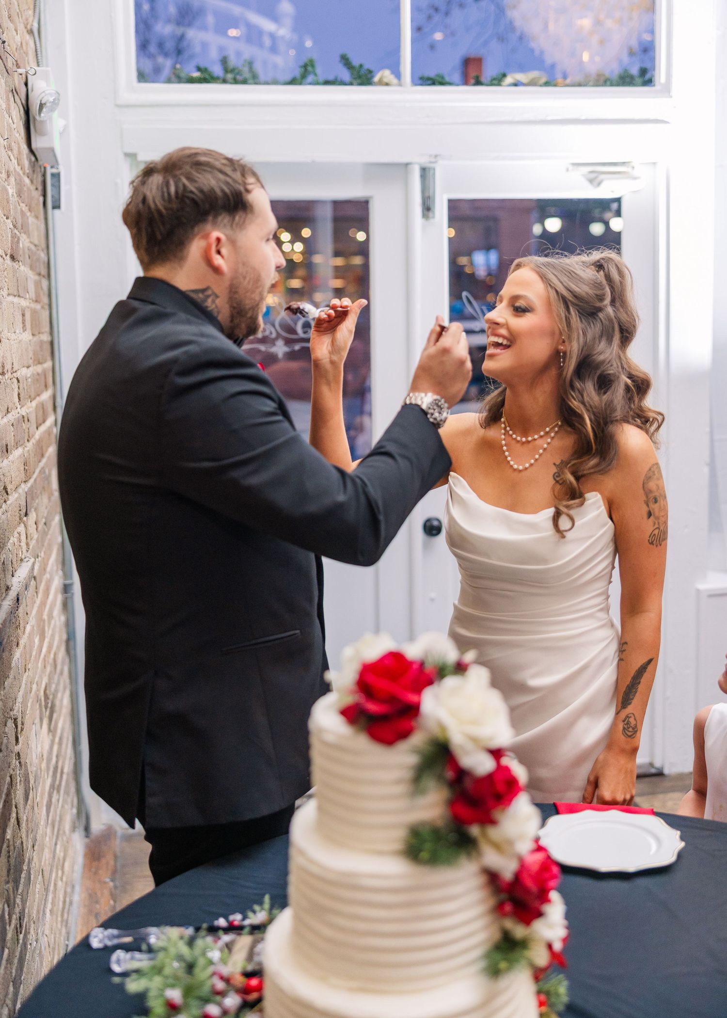 Couple sharing cake during traditional wedding cake cutting ceremony wedding groom bride wilmington North Carolina photographer light airy