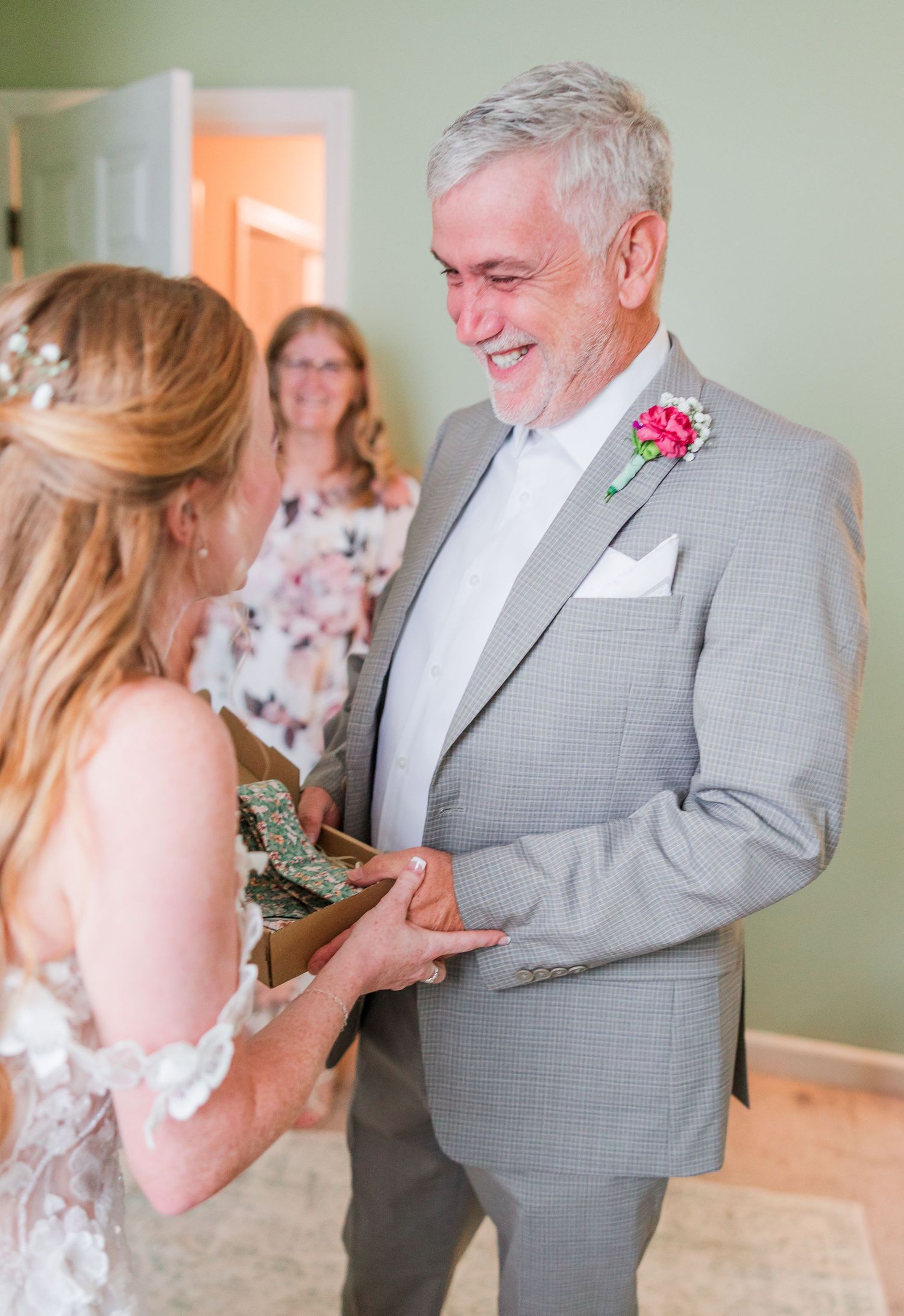 A touching first look moment between wedding couple in gray suit and white dress in a backyard wedding in wilmington, nc