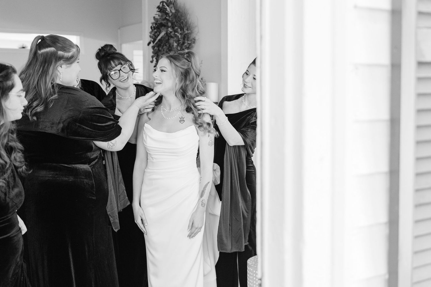 Black and white image of wedding preparations through a doorway marked 104.