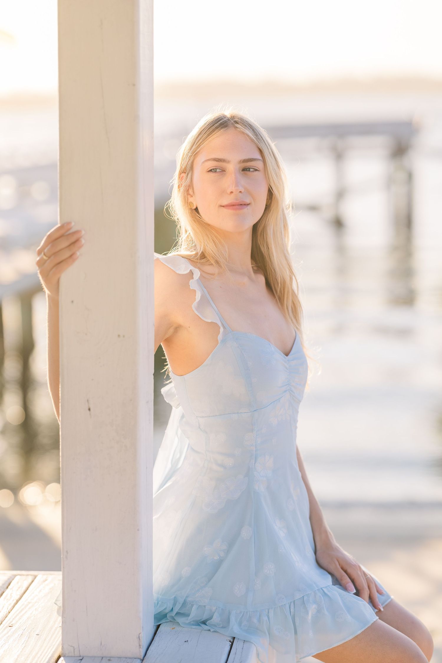Soft blue sundress captured in bright natural light against white architectural details.