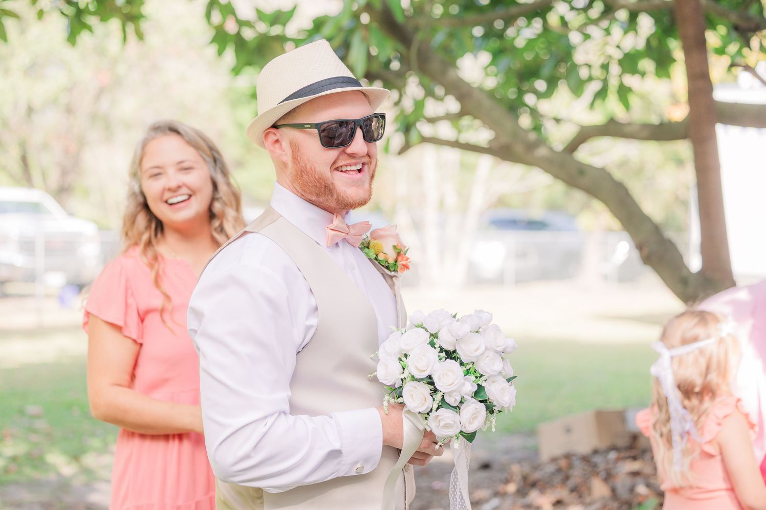 Joyful wedding moment outdoors with bright coral dress and white bouquet wedding groom bride wilmington photographer light and airy classic