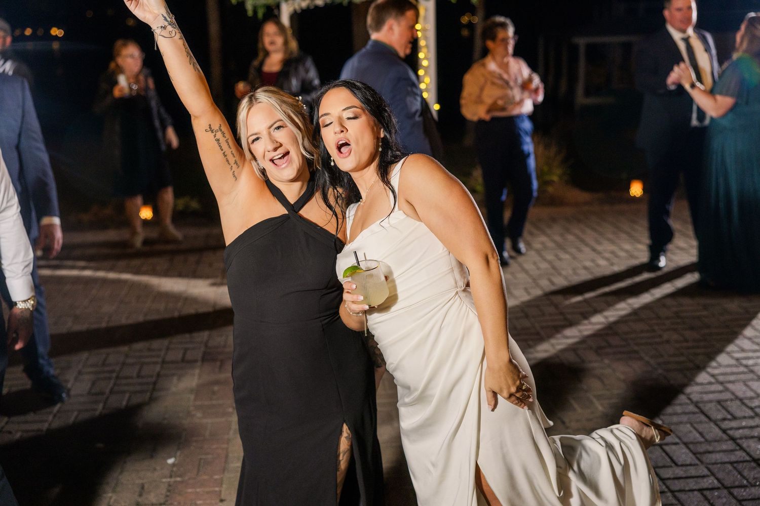 Wedding guests dancing and enjoying themselves at outdoor evening reception wedding groom bride lake Gaston photographer light airy