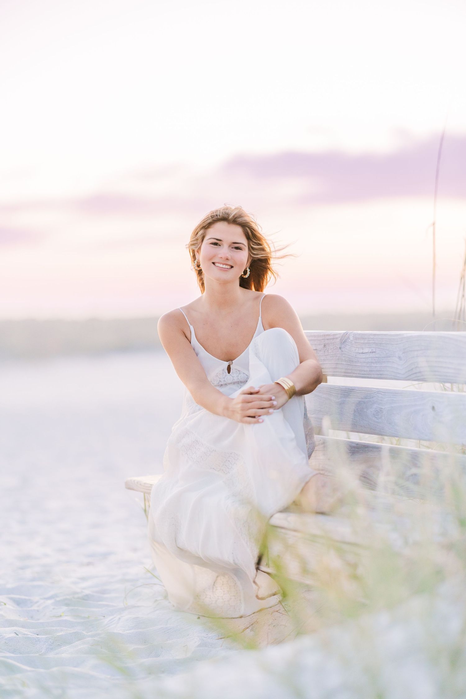 Candid seaside photo session with flowing white fabric and natural lighting.