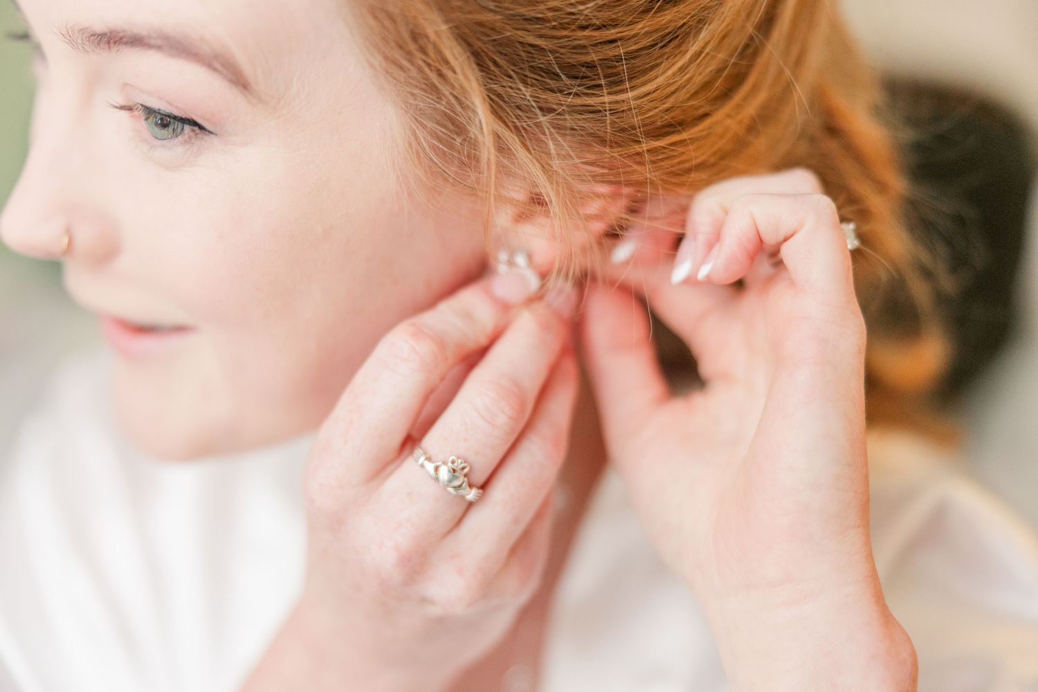 Close-up of earrings being put on during wedding preparations wedding groom bride wilmington North Carolina photographer light and airy