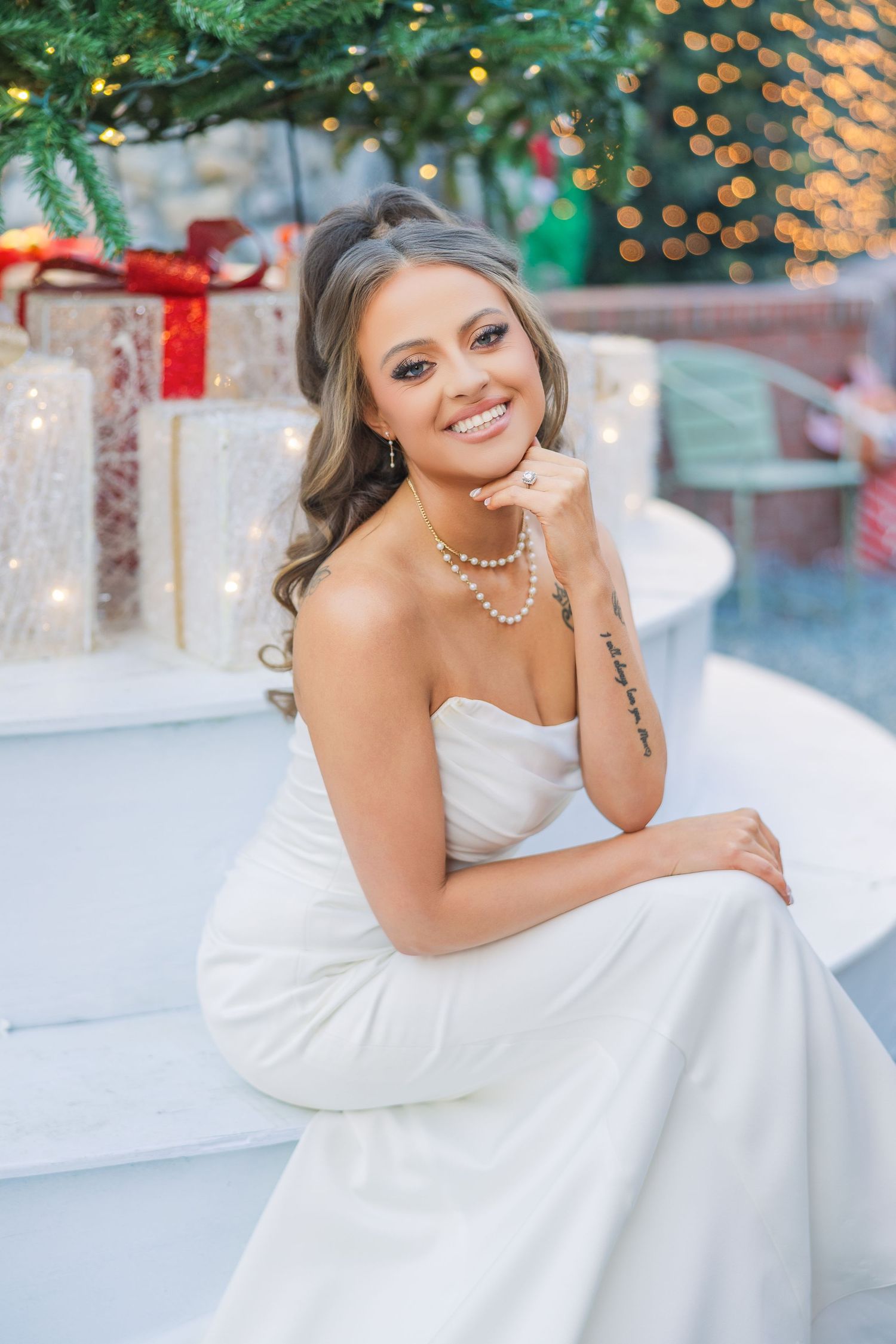 Elegant bridal portrait with Christmas decorations and wrapped presents in background.