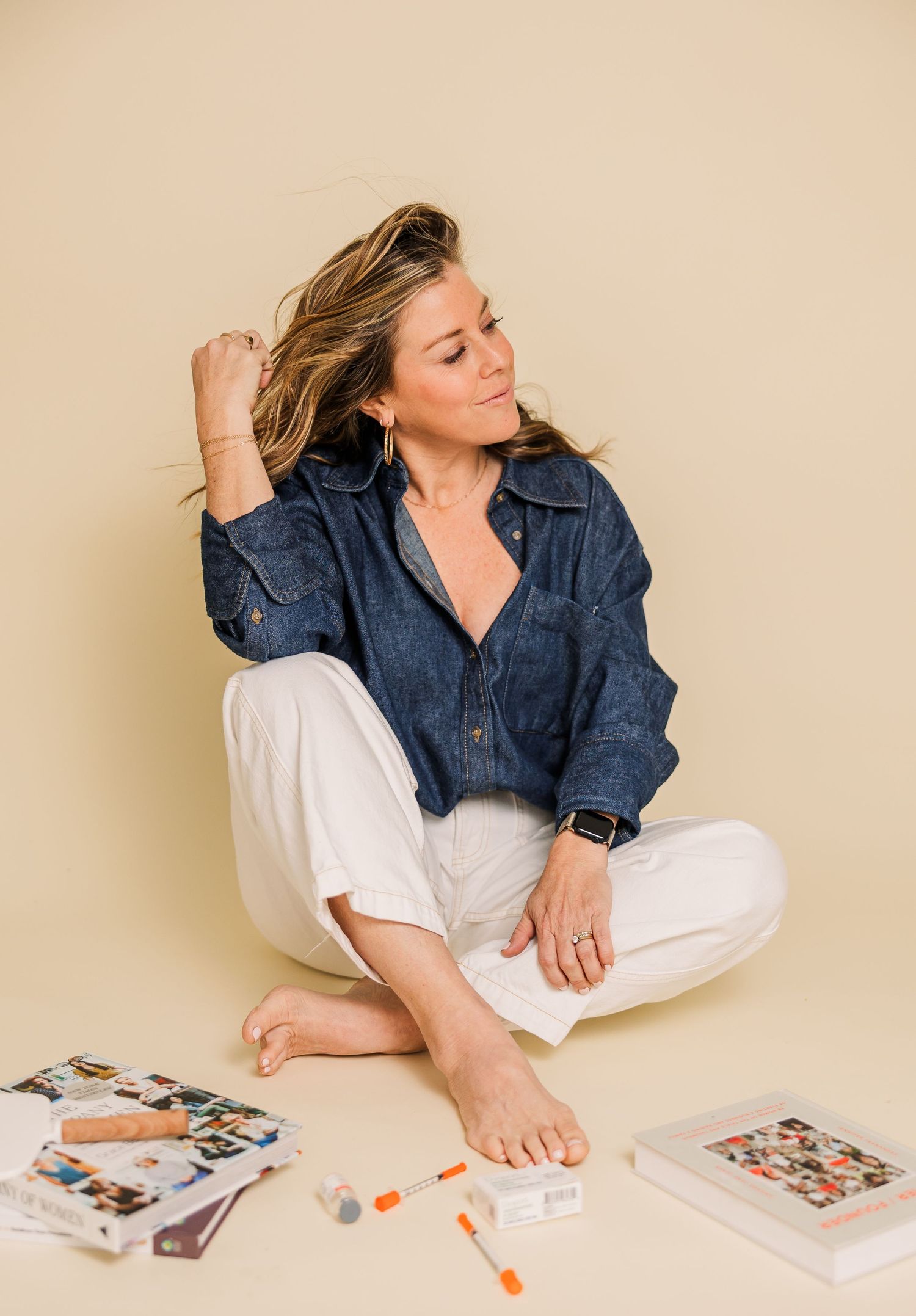 Casual lifestyle portrait with denim shirt and white pants on beige background with scattered photos.