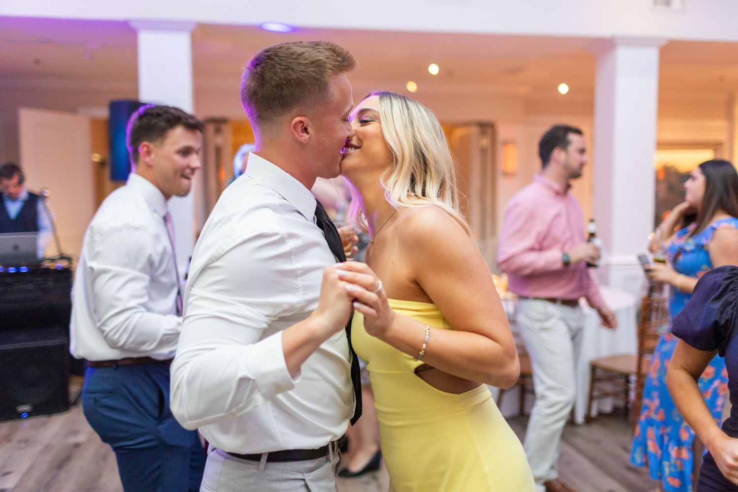 Wedding guests dance and celebrate together at a lively reception party  landfall wedding bride groom light and airy classic wilmington