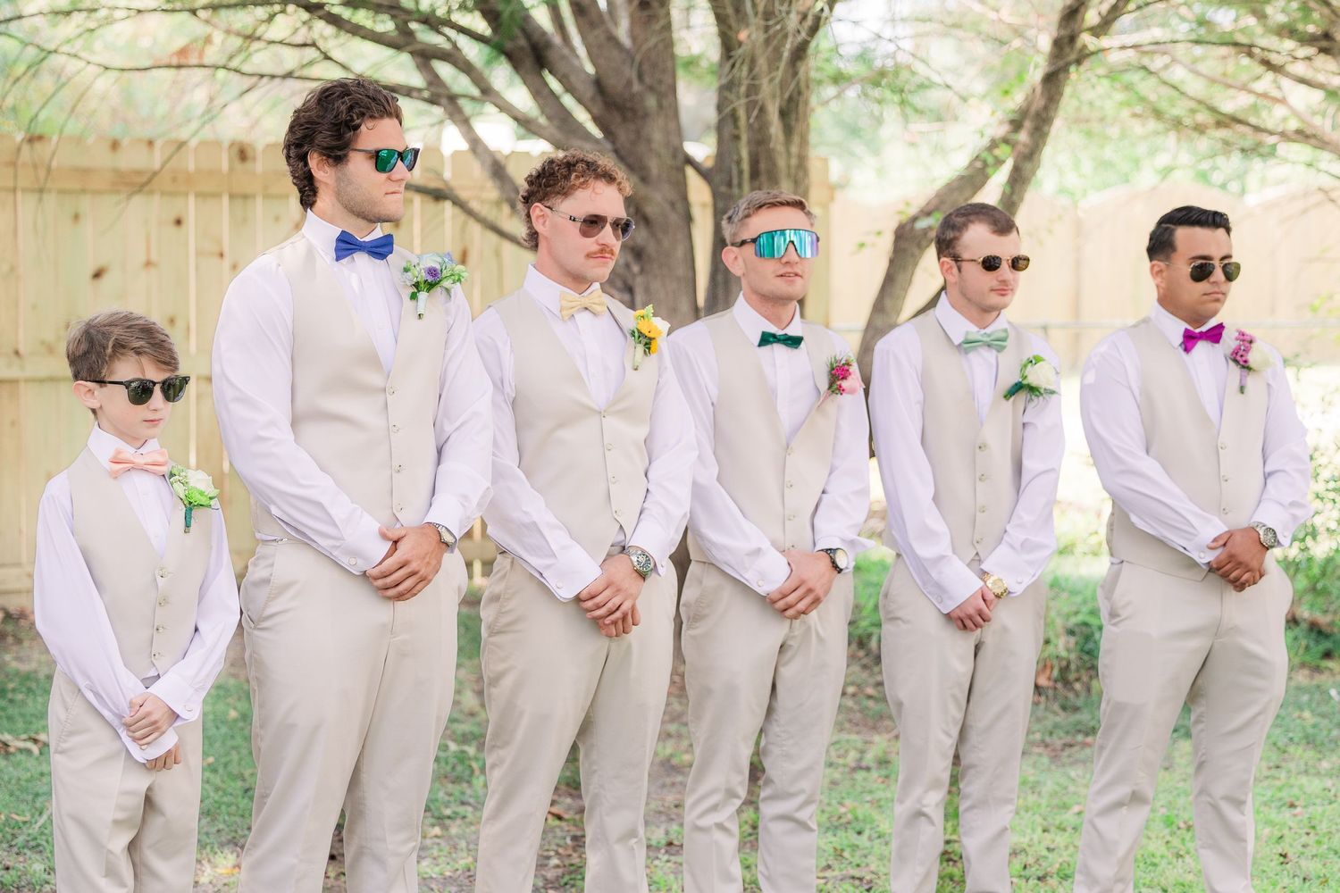 Wedding party in light beige suits and sunglasses poses together outdoors wedding groom bride wilmington photographer light and airy classic
