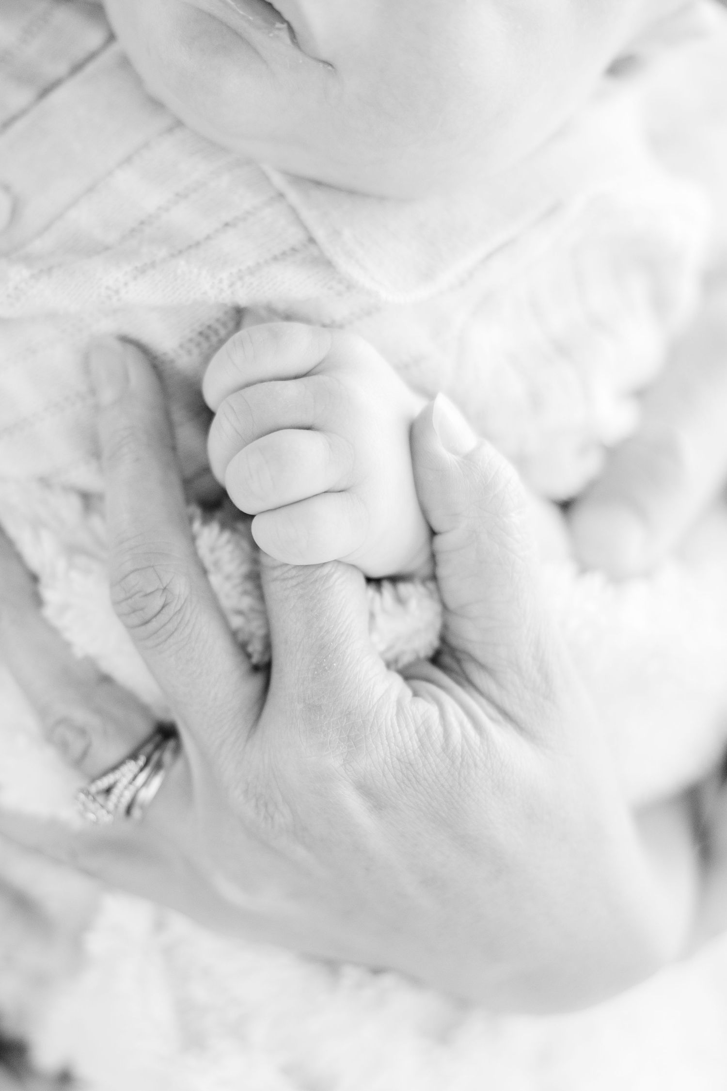 Close-up black and white image of baby's tiny hand grasping.