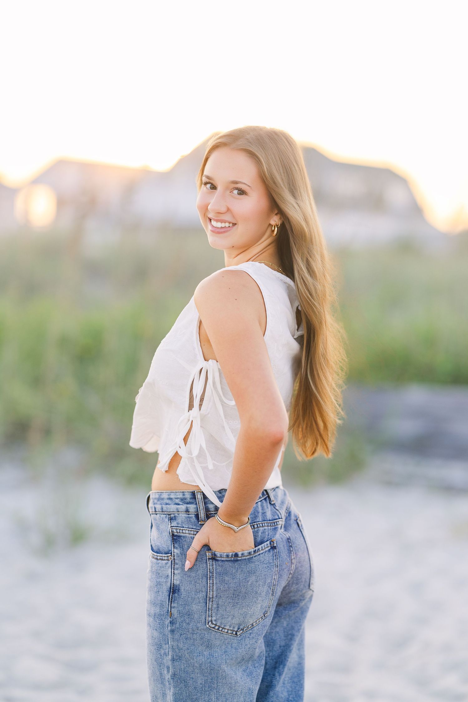 Beachy lifestyle portraits with casual denim and white top during golden hour.