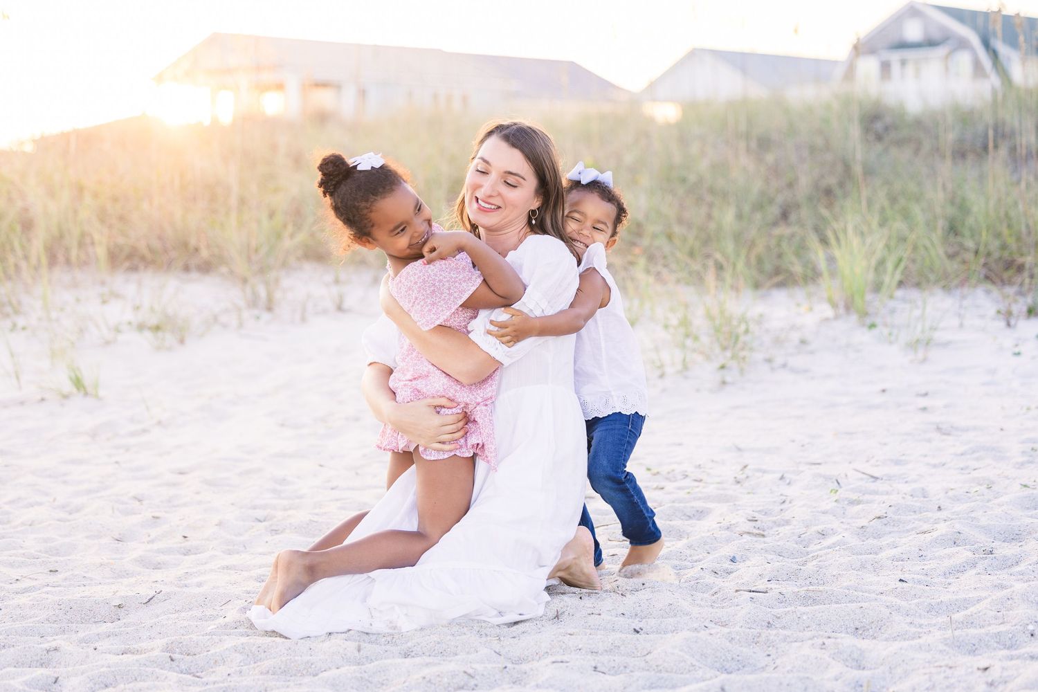 Casual beach photoshoot featuring family members playing and laughing together.