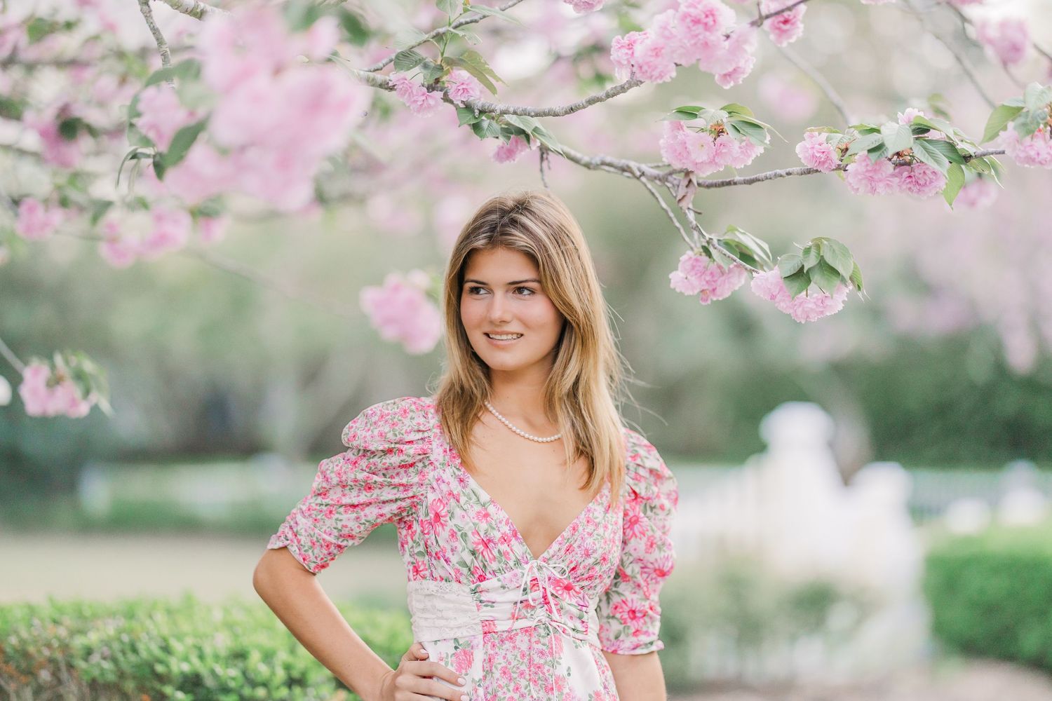 Spring fashion shoot with pink cherry blossoms and floral dress.