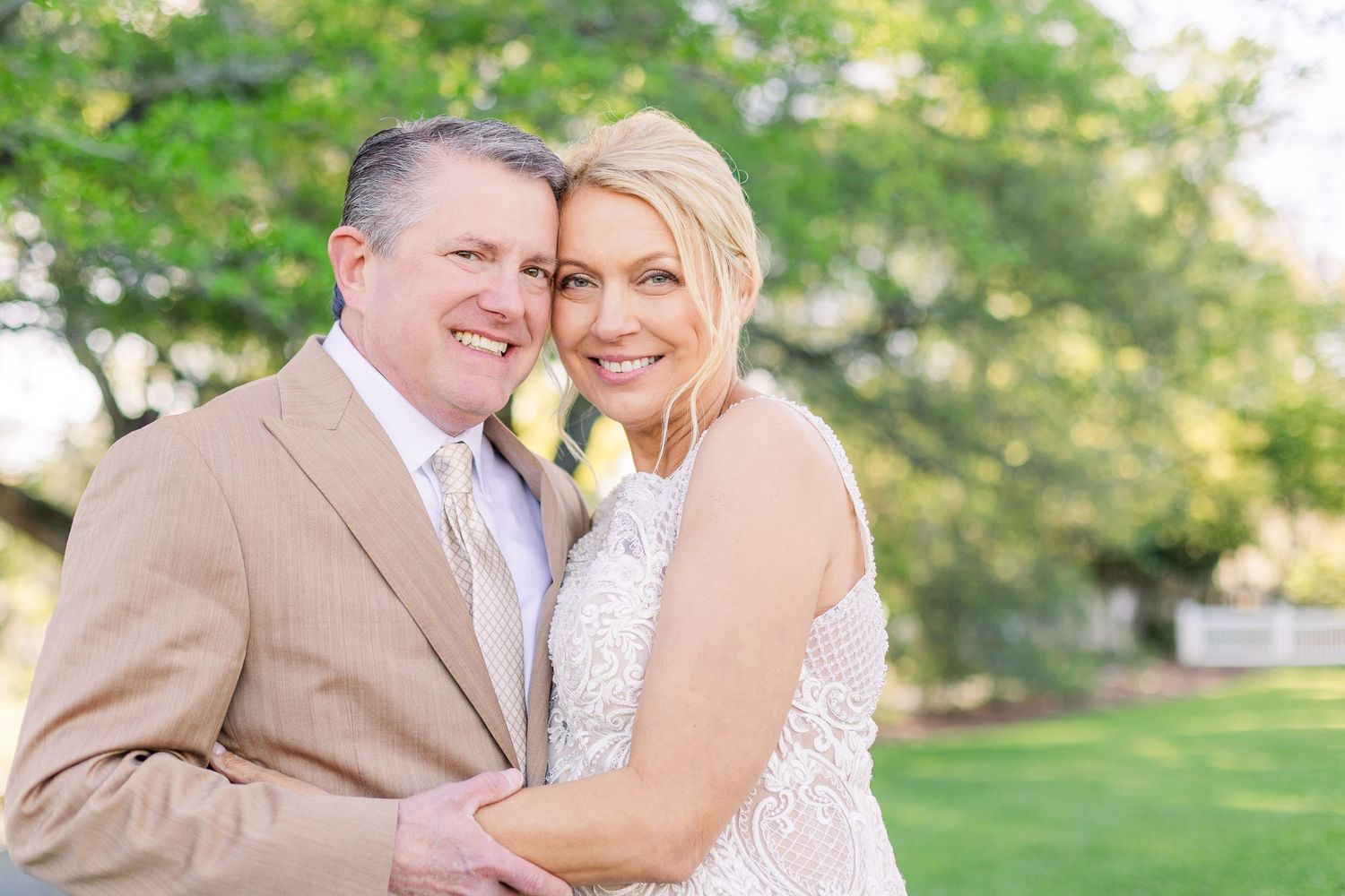 A couple shares a romantic moment in a lush green garden setting.
