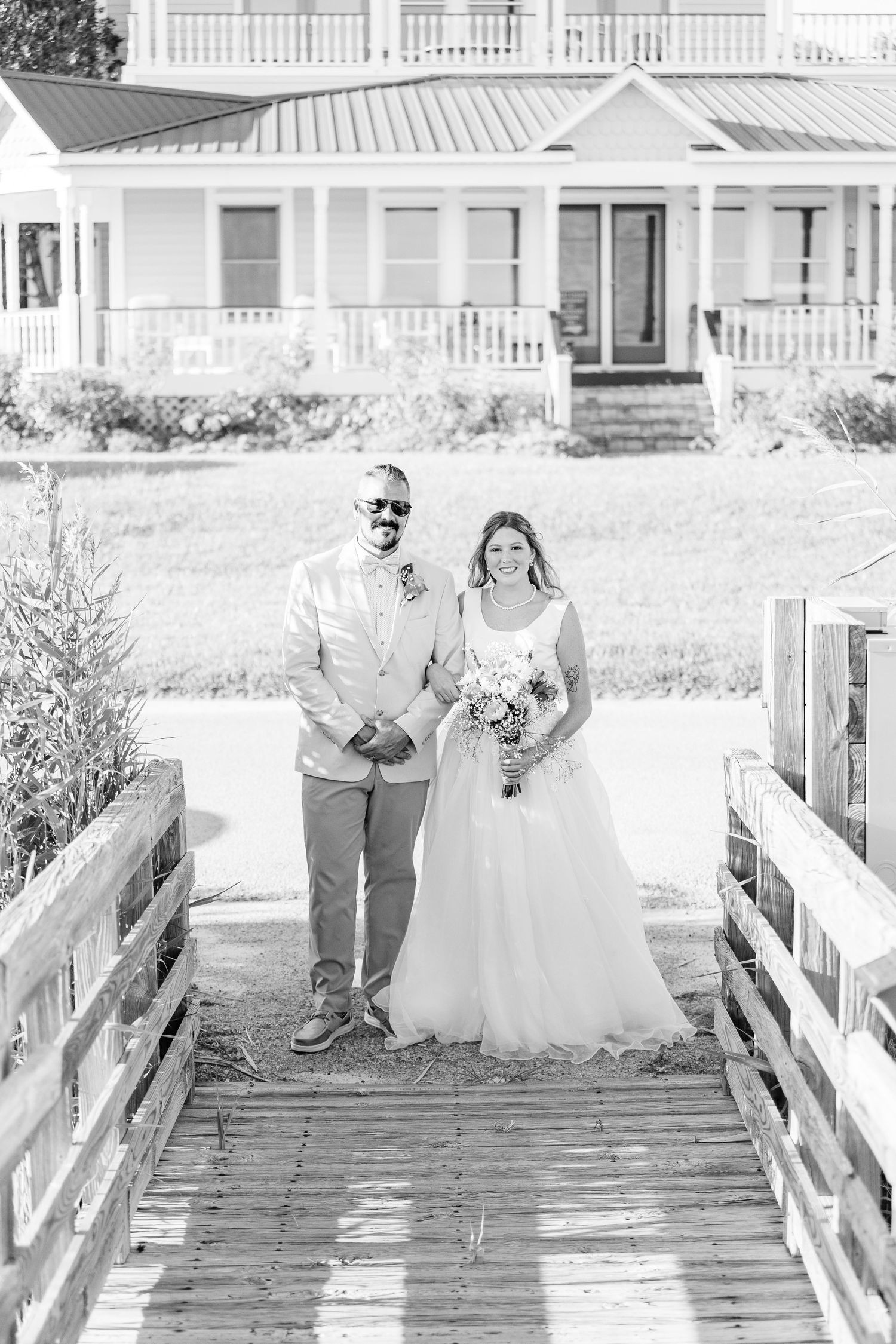 Wedding photos on wooden bridge with white houses and porches in background southport elopement wedding bride groom light and airy classic