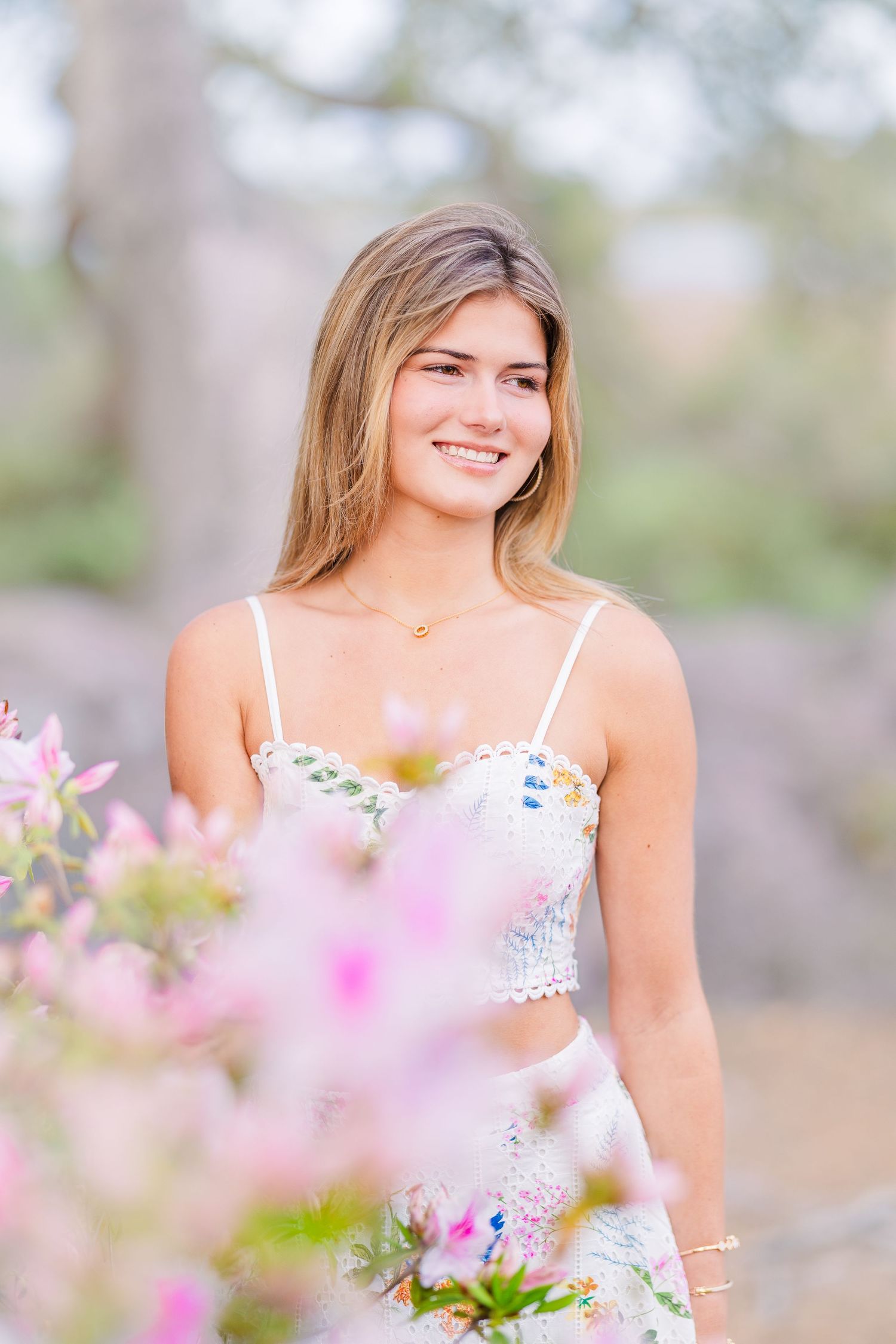 Spring portrait with pink flowers blooming in soft focus against natural backdrop.
