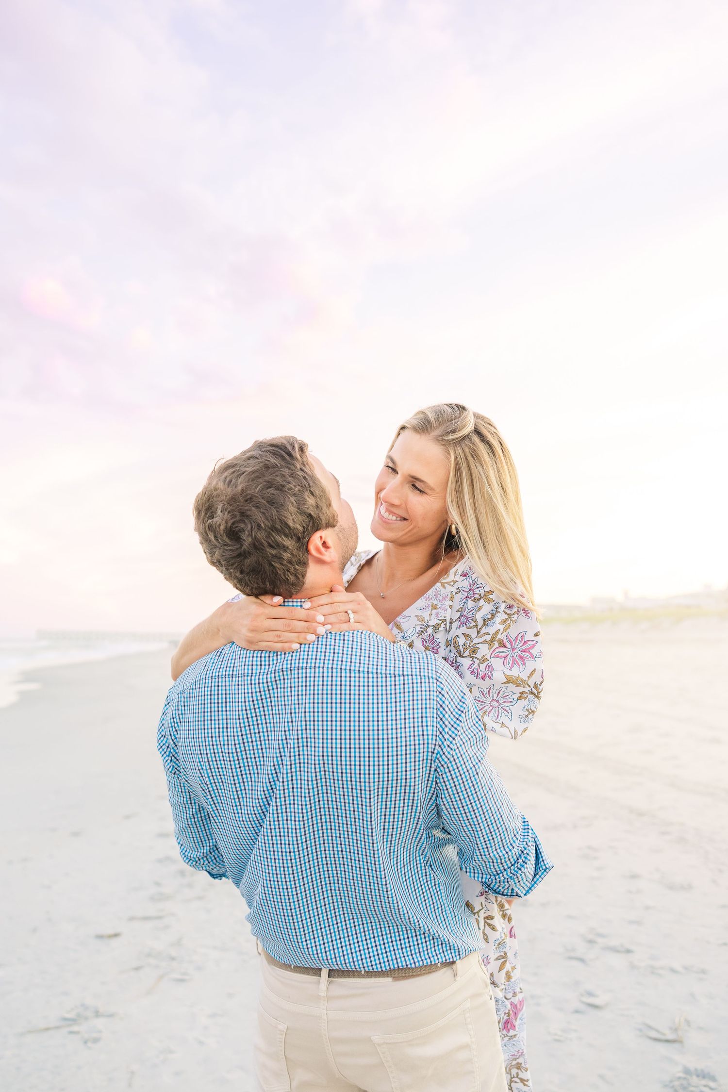 Intimate beach portrait of couple laughing together at sunset.