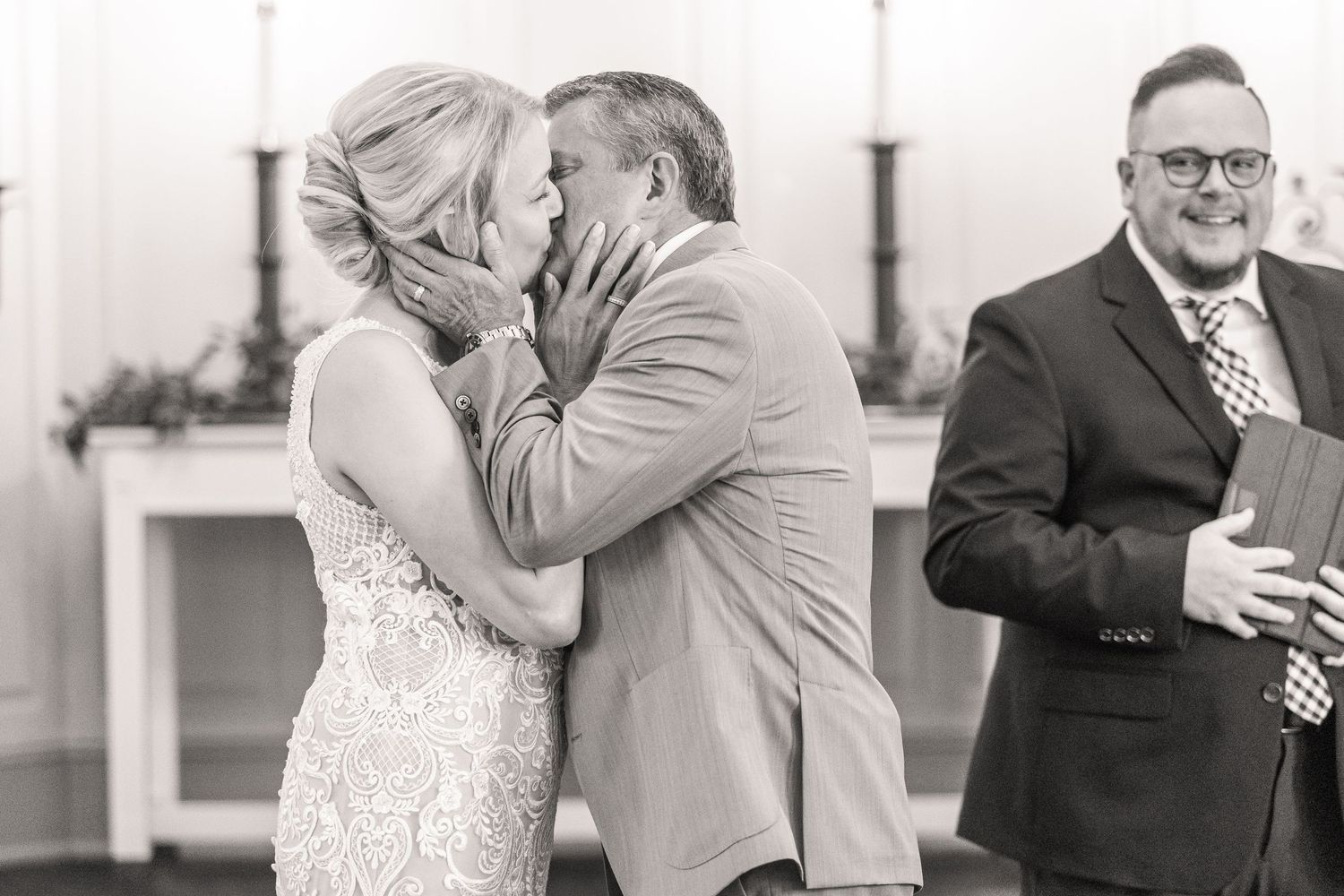 Black and white photo captures emotional reactions during wedding ceremony.